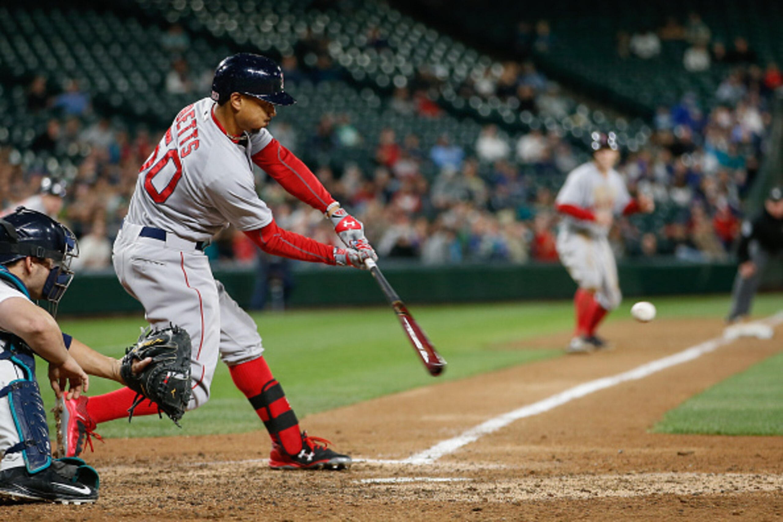 SEATTLE, WA - MAY 14:  Mookie Betts #50 of the Boston Red Sox hits a sacrifice fly against the Seattle Mariners in the ninth inning at Safeco Field on May 14, 2015 in Seattle, Washington. Brock Holt #26 scored from third as the Mariners were charged with 