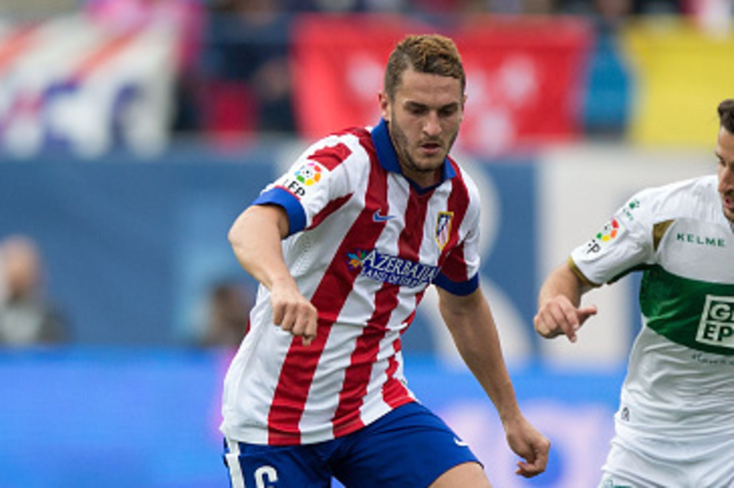 MADRID, SPAIN - APRIL 25: Koke (L) of Atletico de Madrid competes for the ball with Ferran Corominas (R) of Elche FC during the La Liga match between Club Atletico de Madrid and Elche FC at Vicente Calderon Stadium on April 25, 2015 in Madrid, Spain.  (Ph