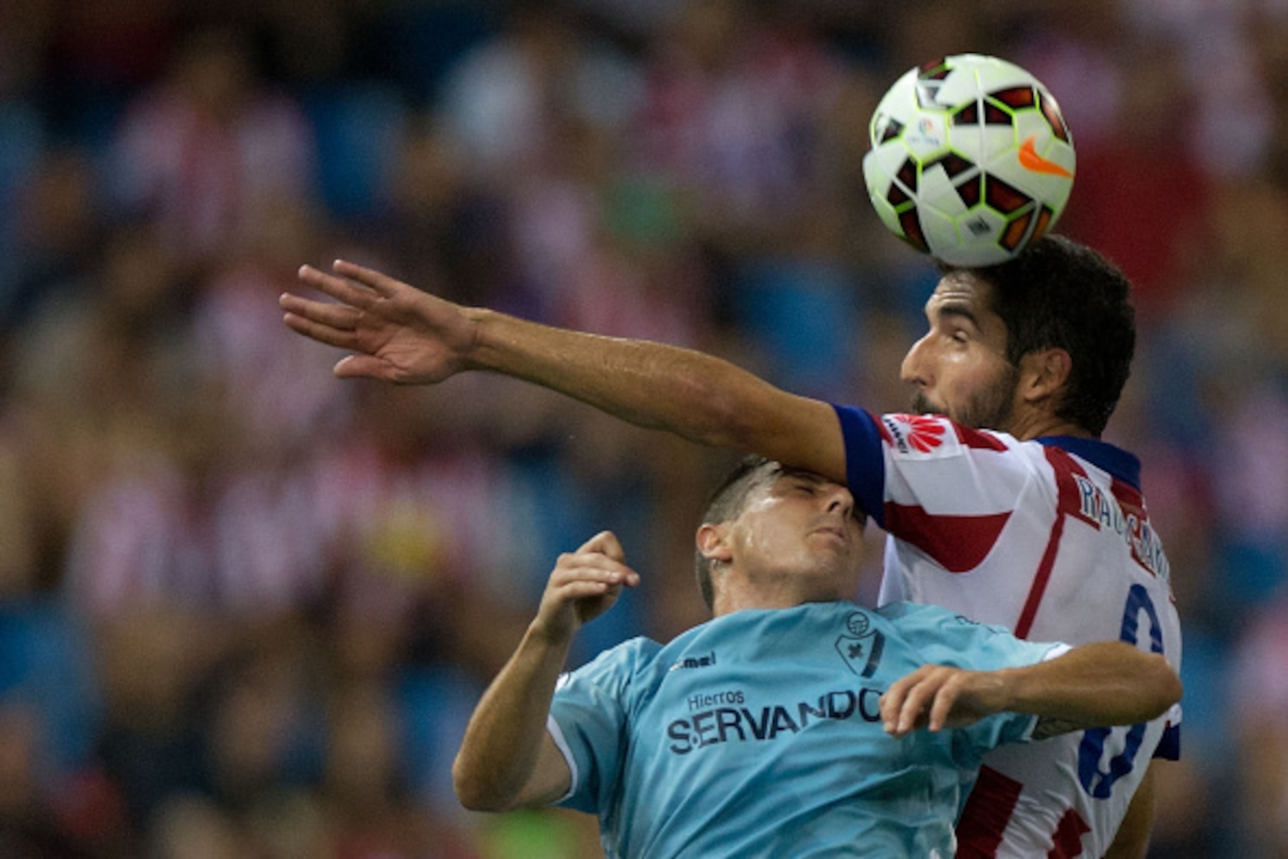 MADRID, SPAIN - AUGUST 30: Raul Garcia of Atletico de Madrid wins the header before Abraham MInero Fernandez of SD Eibar during the La Liga match between Club Atletico de Madrid and SD Eibar at Vicente Calderon Stadium on August 30, 2014 in Madrid, Spain. MADRID, SPAIN - AUGUST 30: Raul Garcia of Atletico de Madrid wins the header before Abraham MInero Fernandez of SD Eibar during the La Liga match between Club Atletico de Madrid and SD Eibar at Vicente Calderon Stadium on August 30, 2014 in Madrid, Spain.