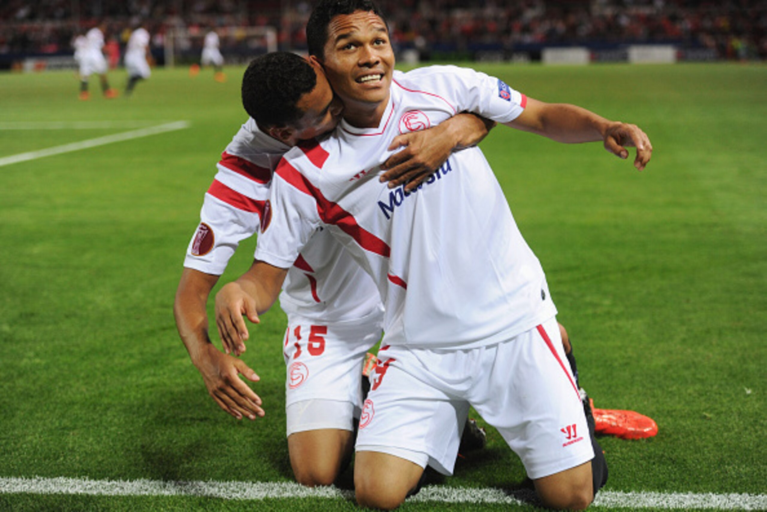 SEVILLE, SPAIN - APRIL 16:  Carlos Bacca of Sevilla (9) celebrates with Timothee Kolodziejczak (15) as as he scores their first goal during the UEFA Europa League Quarter Final first leg match between FC Sevilla and FC Zenit at Estadio Ramon Sanchez Pizju