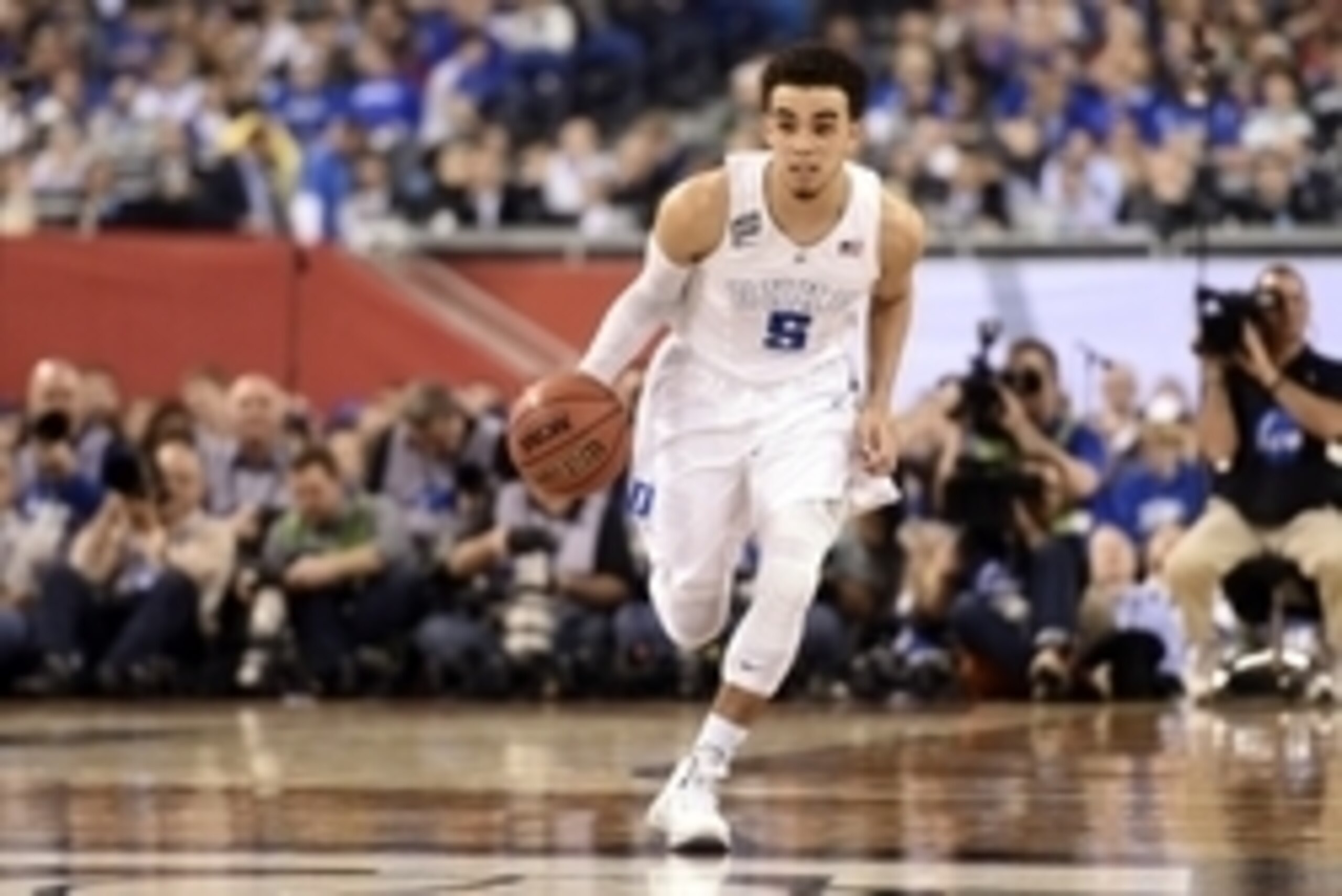 Apr 4, 2015; Indianapolis, IN, USA; Duke Blue Devils guard Tyus Jones (5) brings the ball up court against the Michigan State Spartans in the first half of the 2015 NCAA Men's Division I Championship semi-final game at Lucas Oil Stadium. Mandatory Credit: