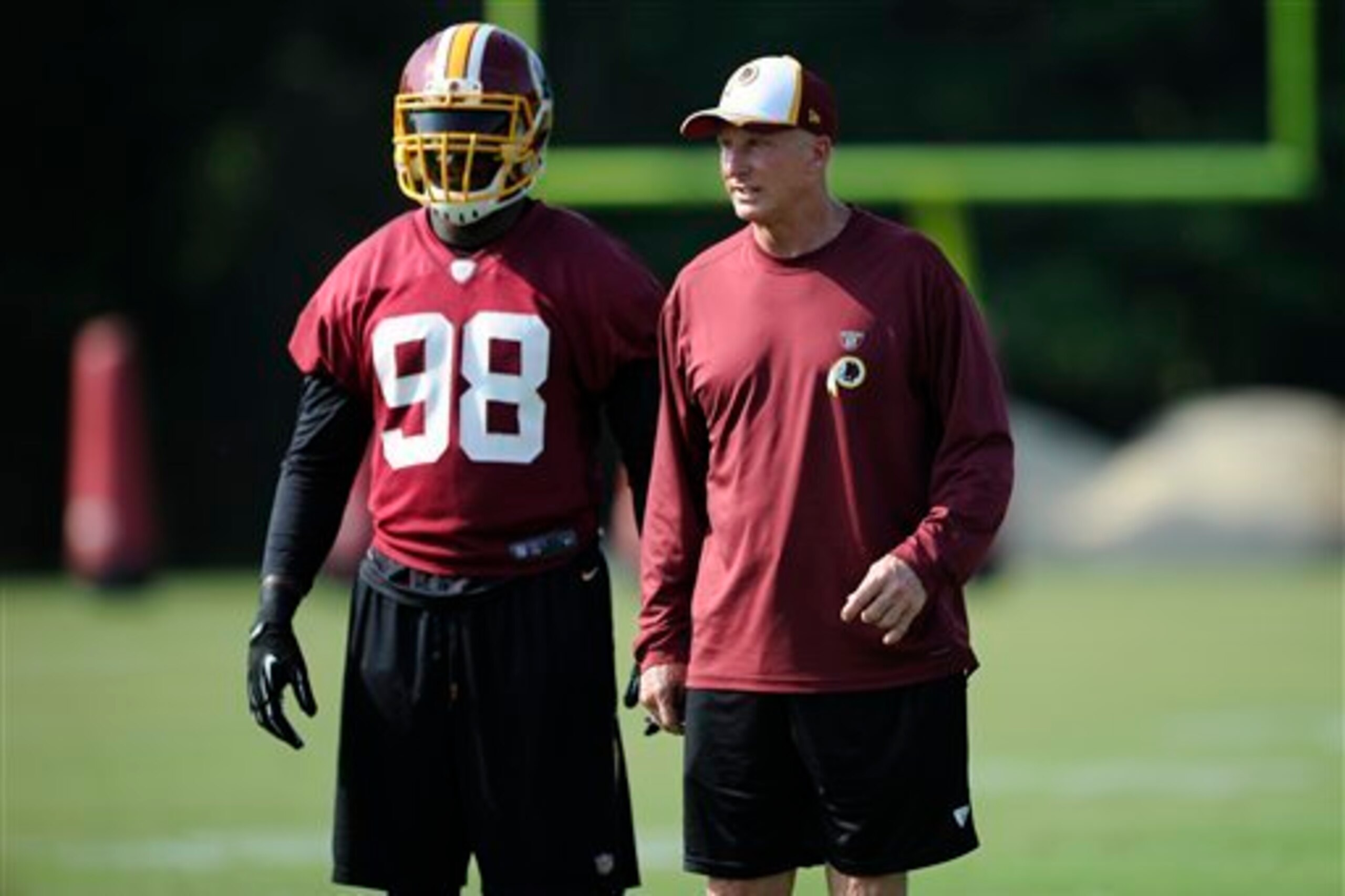 Haslett (right) works with Redskins linebacker Brian Orakpo during minicamp in 2014.