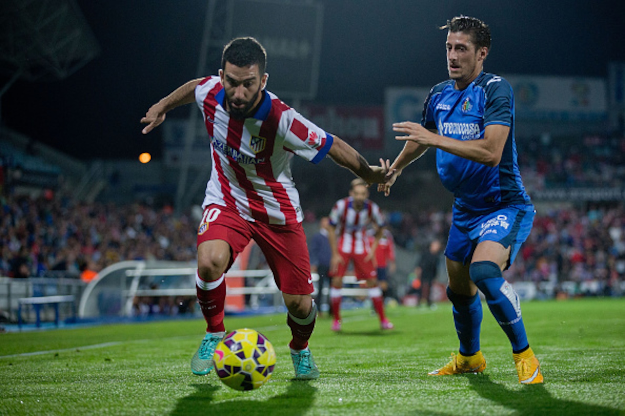 GETAFE, SPAIN - OCTOBER 26:  Arda Turan (R) of Atletico de Madrid competes for the ball with Sergio Escudero (L) of Getafe CF during the La Liga match between Getafe CF and Club Atletico de Madrid at Coliseum Alfonso Perez on October 26, 2014 in Getafe, S