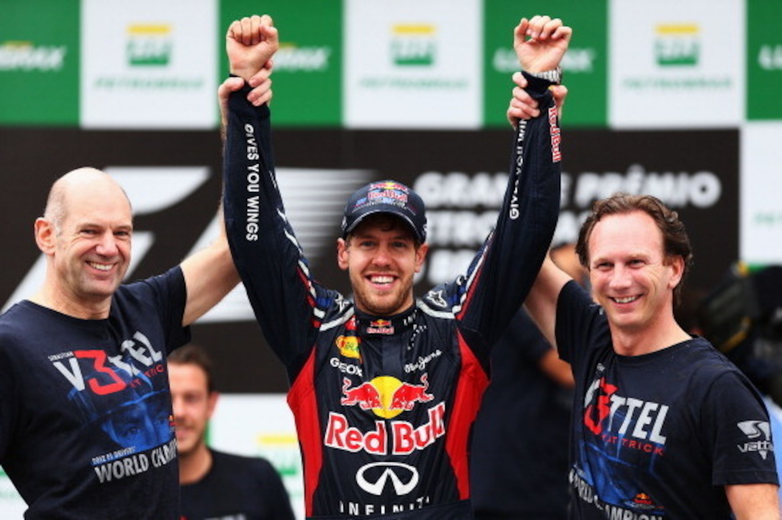 SAO PAULO, BRAZIL - NOVEMBER 25:  Sebastian Vettel (C) of Germany and Red Bull Racing celebrates with Red Bull Racing Chief Technical Officer Adrian Newey (L) and Team Principal Christian Horner (R) on the podium as he finishes in sixth position and clinc