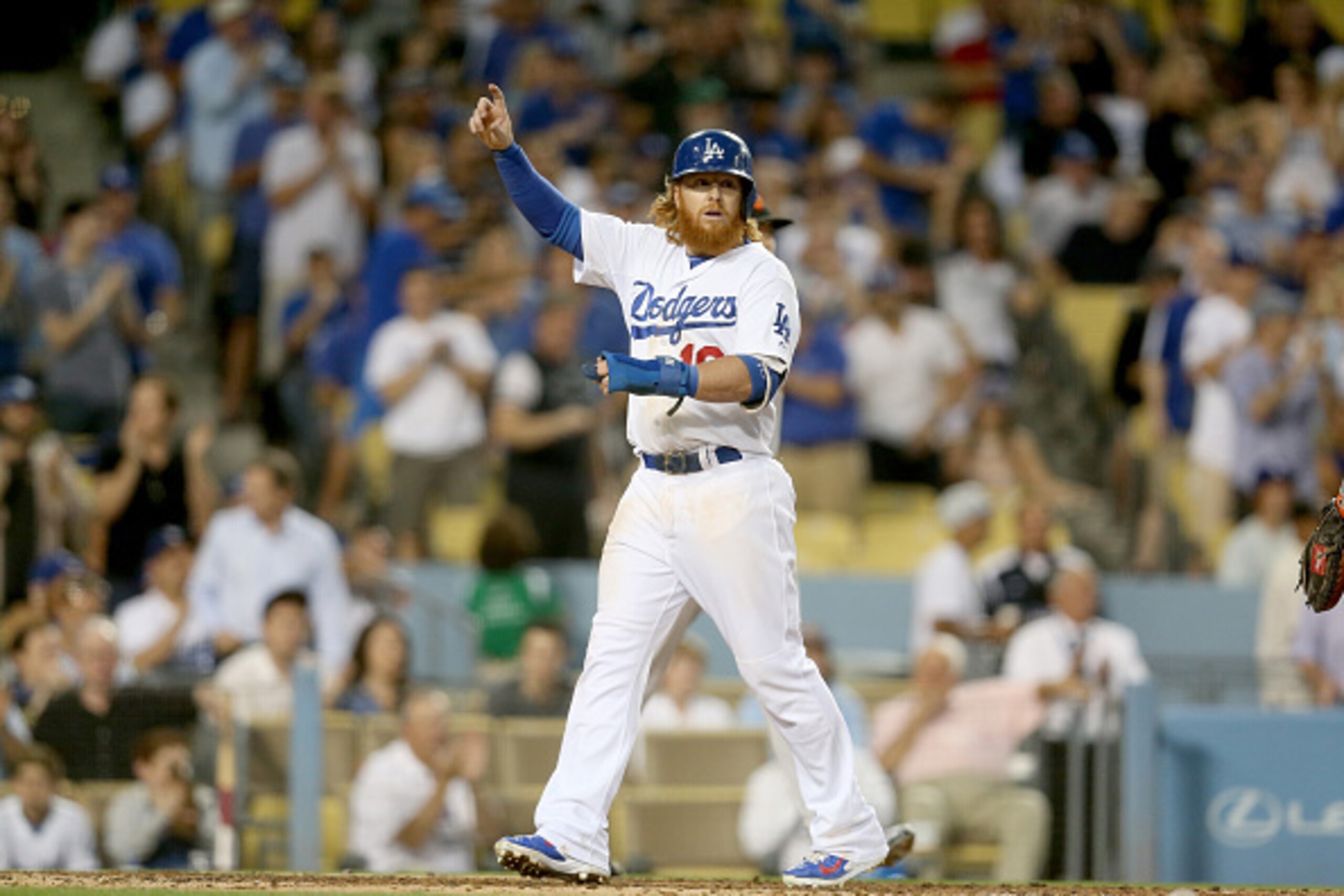 LOS ANGELES, CA - JUNE 19: Justin Turner #10 of the Los Angeles Dodgers signals to Adrian Gonzalez #23 after Turner scored on Gonzalez' single in the third inning against the San Francisco Giants at Dodger Stadium on June 19, 2015 in Los Angeles, Californ