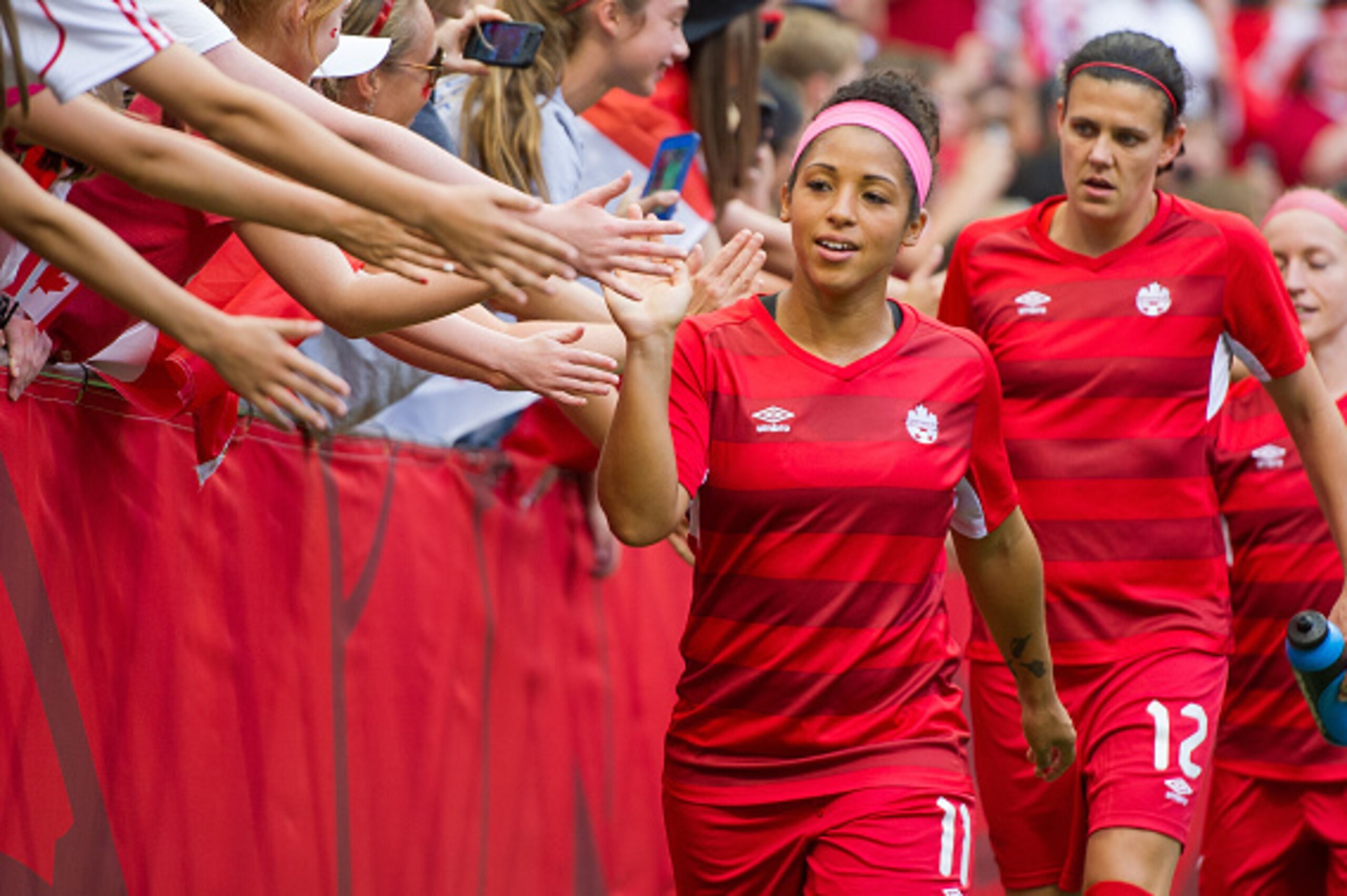 VANCOUVER, BC - JUNE 21: Desiree Scott #11 and Christine Sinclair #12 of Canada high fives fans after the team warmup prior to the start of the FIFA Women's World Cup Canada 2015 Round of 16 match between Switzerland and Canada June, 21, 2015 at BC Place 