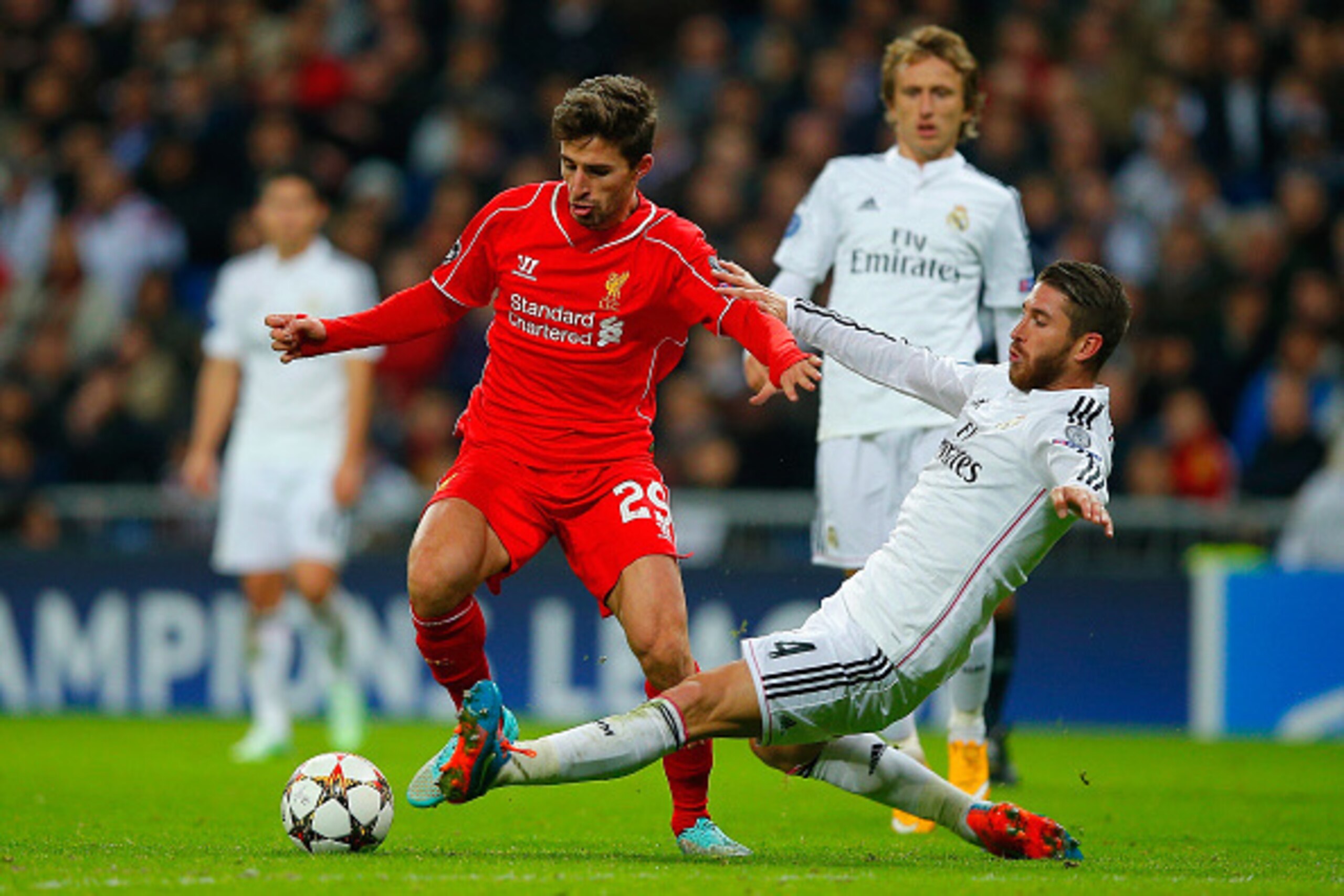 MADRID, SPAIN - NOVEMBER 04:  Sergio Ramos of Real Madrid CF tackles Fabio Borini of Liverpool during the UEFA Champions League Group B match between Real Madrid CF and Liverpool FC at Estadio Santiago Bernabeu on November 4, 2014 in Madrid, Spain.  (Phot