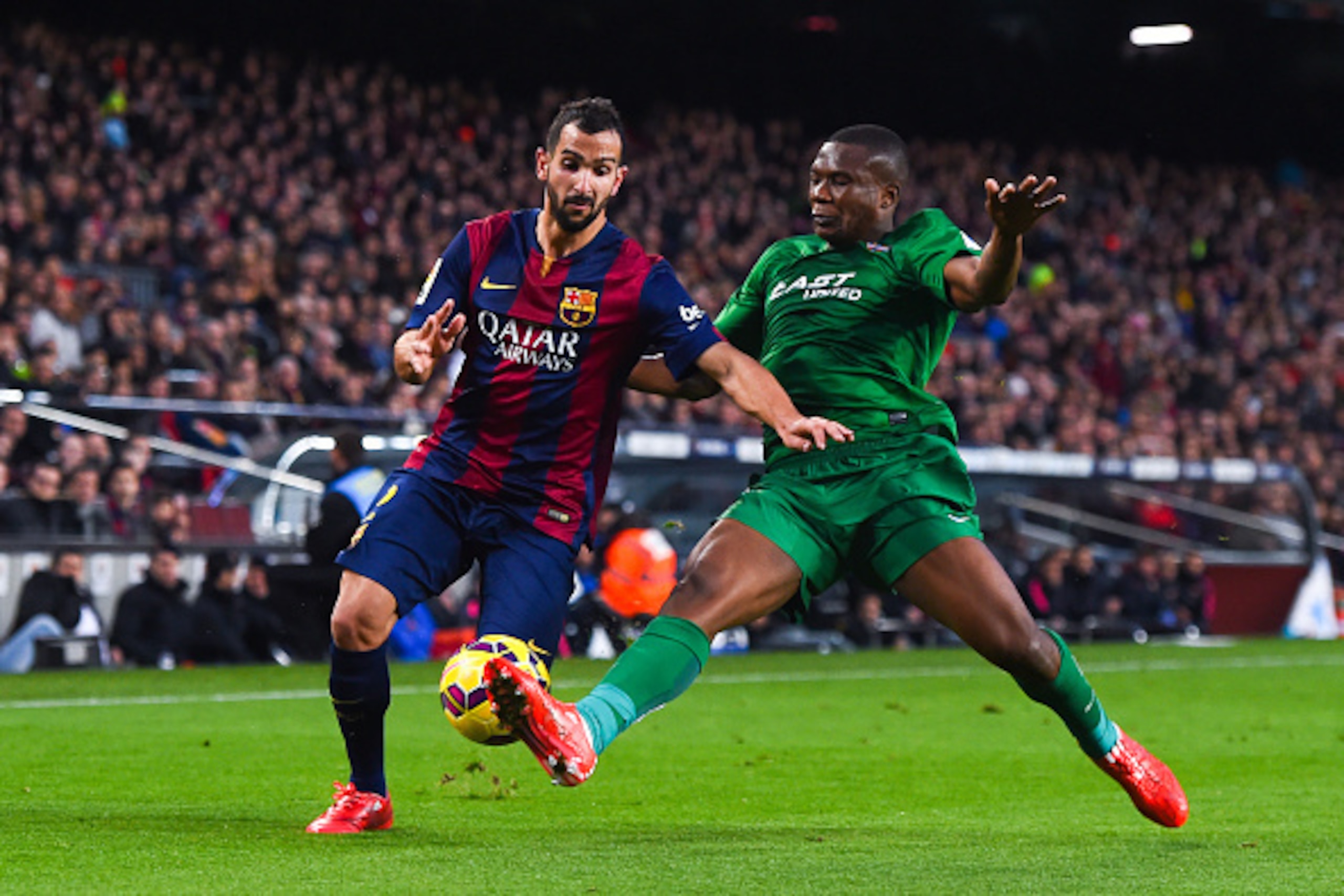 BARCELONA, SPAIN - FEBRUARY 15: Martin Montoya of FC Barcelona competes for the ball with Simao Mate Junior of Levante UD during the La Liga match between FC Barcelona and Levante UD at Camp Nou on February 15, 2015 in Barcelona, Spain.  (Photo by David R