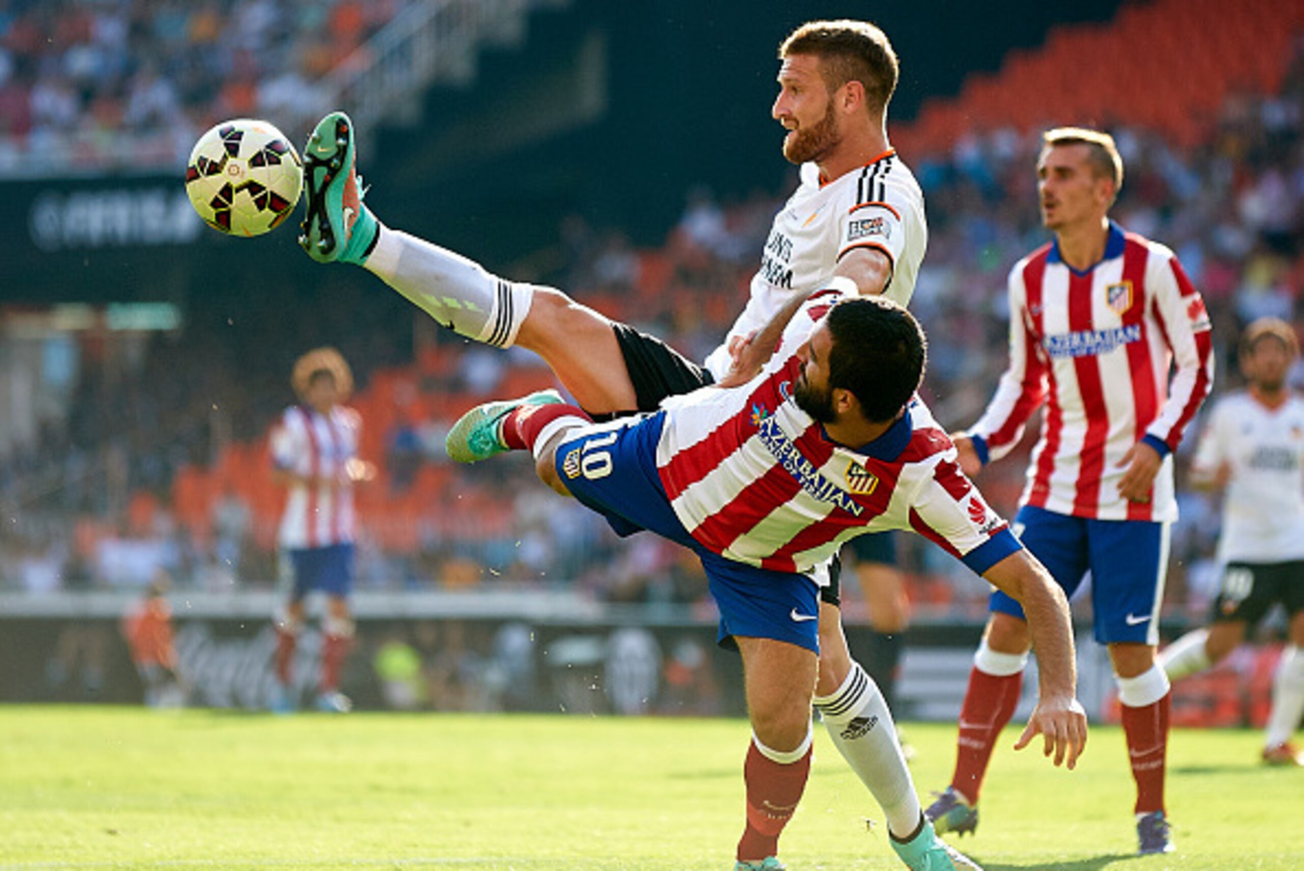 VALENCIA, SPAIN - OCTOBER 04:  Arda Turan (R) of Atletico de Madrid is tackled by Shkodran Mustafi of Valencia during the La Liga match between Valencia CF and Club Atletico de Madrid at Estadi de Mestalla on October 4, 2014 in Valencia, Spain.  (Photo by