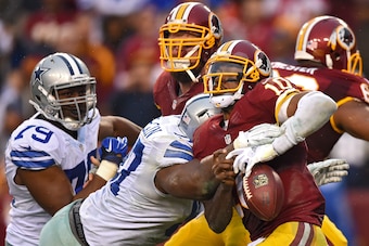 LANDOVER, MD - DECEMBER 28: Quarterback Robert Griffin III #10 of the Washington Redskins fumbles the ball as he is sacked by defensive tackle Terrell McClain #97 of the Dallas Cowboys in the fourth quarter at FedExField on December 28, 2014 in Landover,