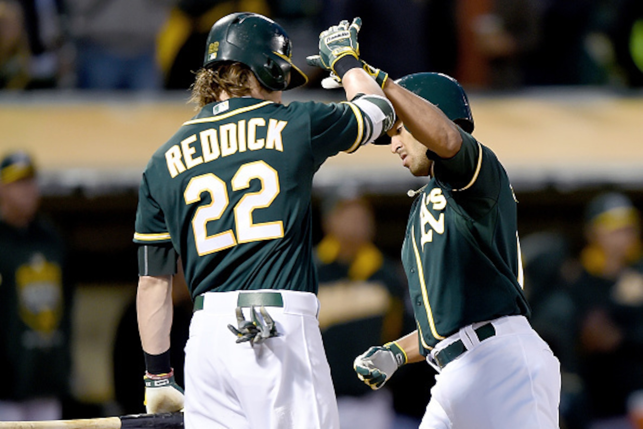 OAKLAND, CA - MAY 12:  Marcus Semien #10 of the Oakland Athletics is congratulated by Josh Reddick #22 after hitting a solo home run against the Boston Red Sox in the bottom of the fourth inning at O.co Coliseum on May 12, 2015 in Oakland, California.  (P