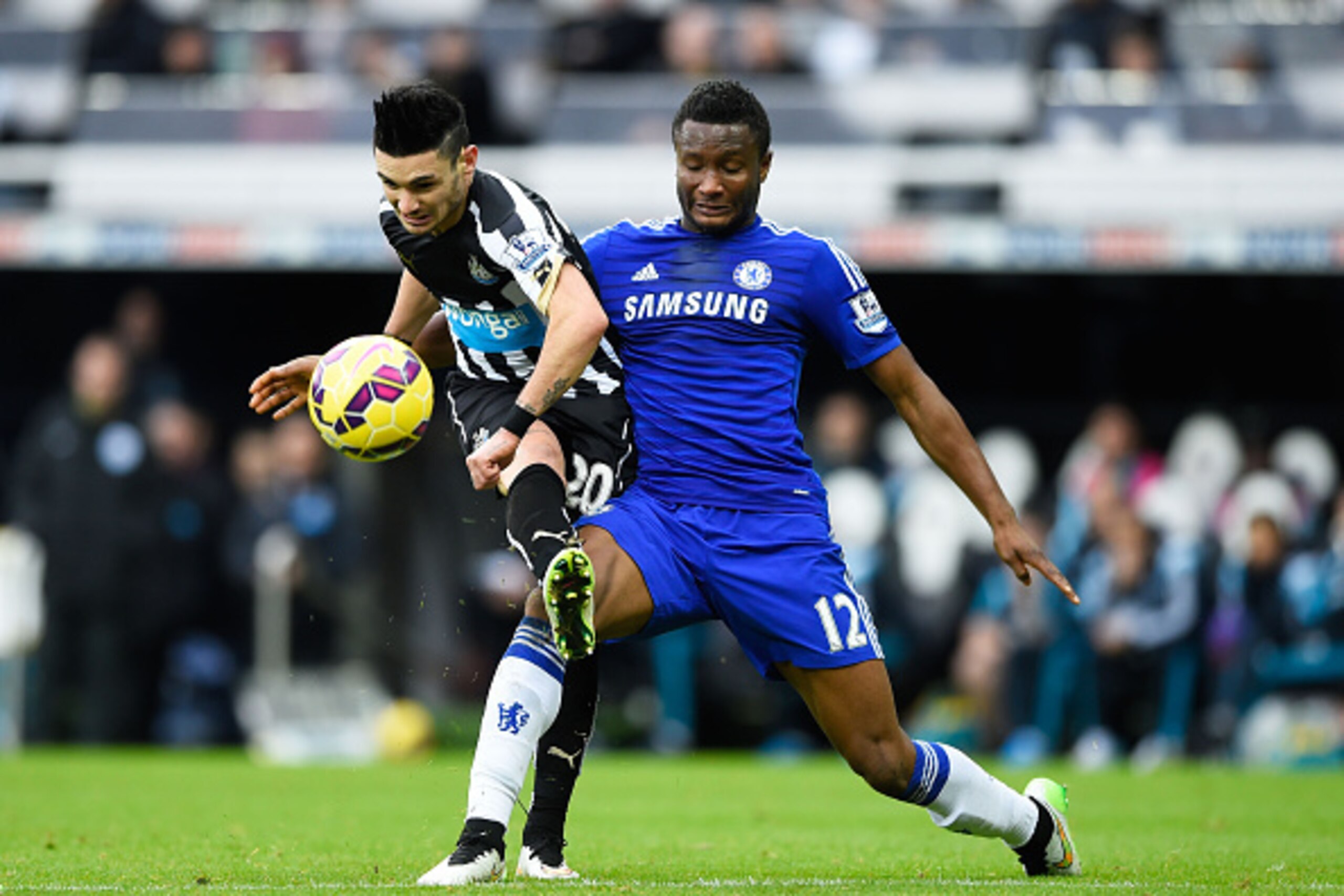 NEWCASTLE UPON TYNE, ENGLAND - DECEMBER 06:  Remy Cabella of Newcastle United gets a shot away under pressure from Mikel John Obi of Chelsea during the Barclays Premier League match between Newcastle United and Chelsea at St James' Park on December 6, 201