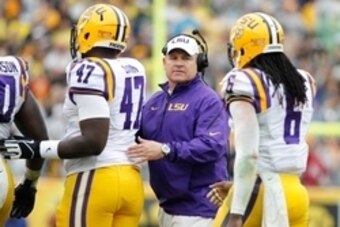 Jan 1, 2014; Tampa, Fl, USA; LSU Tigers head coach Les Miles congratulates defensive tackle Maquedius Bain (47) and safety Craig Loston (6) during the second half against the Iowa Hawkeyes at Raymond James Stadium. LSU Tigers defeated the Iowa Hawkeyes 21