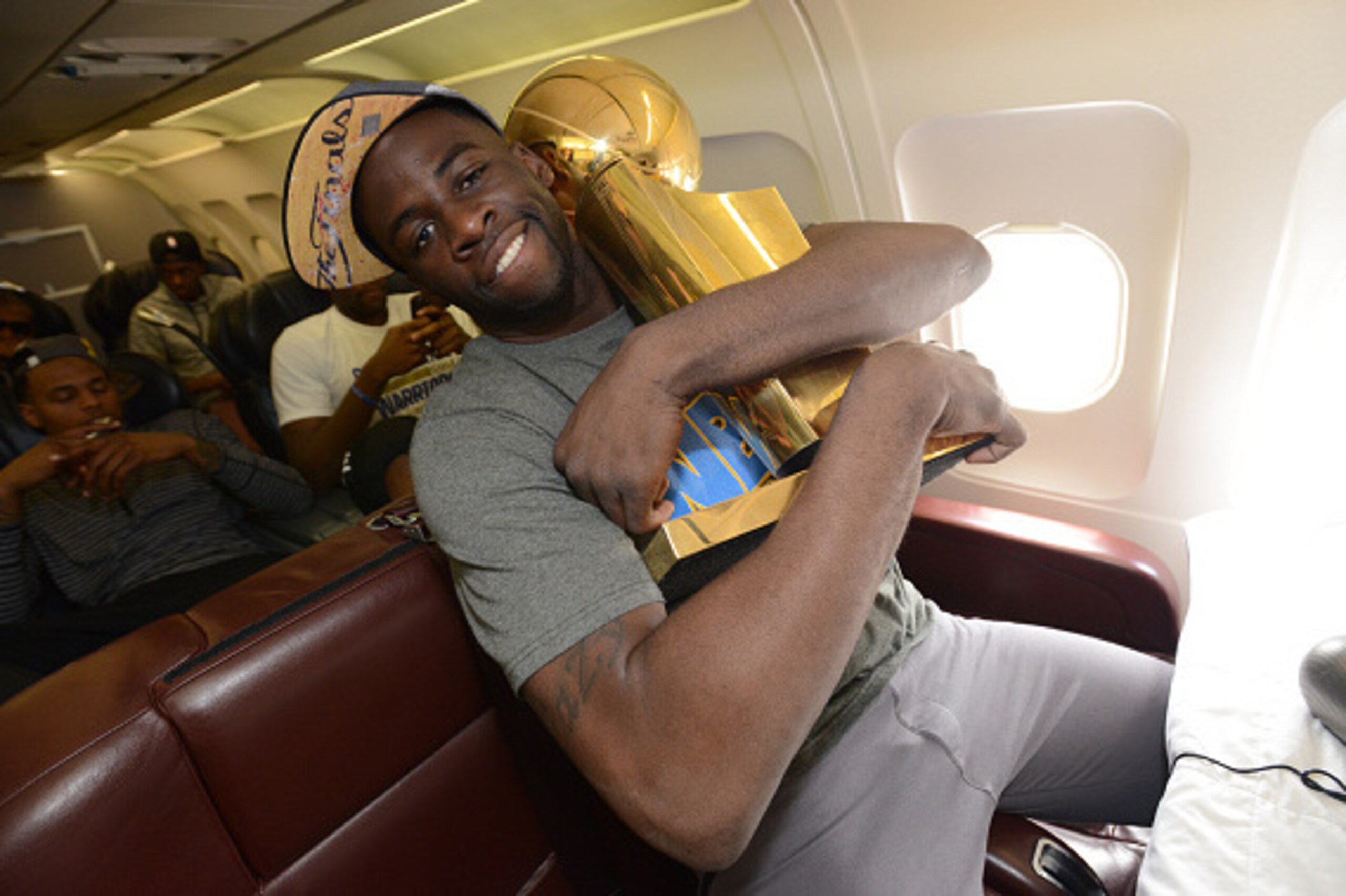 OAKLAND, CA - JUNE 17:  Draymond Green #23 of the Golden State Warriors holds the NBA trophy on the plane as the team travels home from Cleveland after winning the 2015 NBA Finals on June 17, 2015 in Oakland, California. NOTE TO USER: User expressly ackno