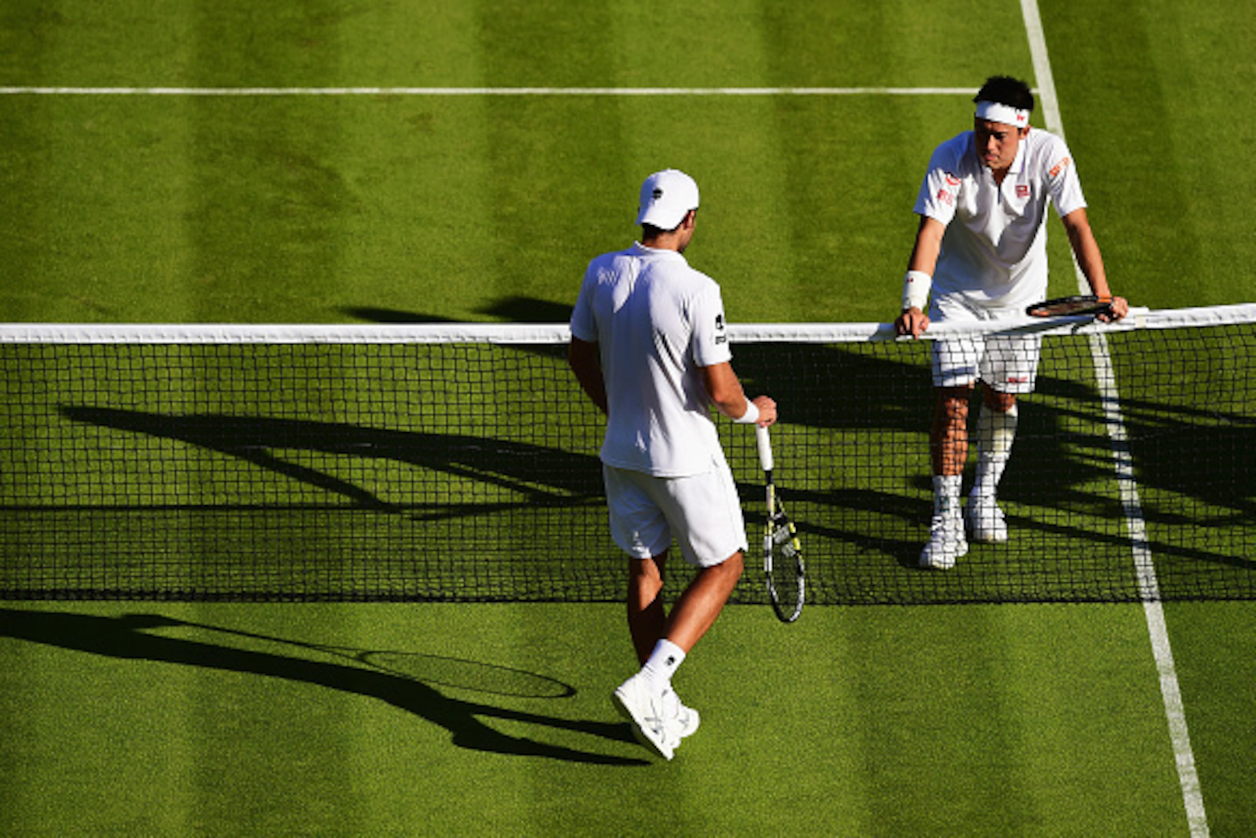 LONDON, ENGLAND - JUNE 29: Kei Nishikori (top) of Japan reacts after winning his GentlemenÂs Singles first round match against Simone Bolelli of Italy during day one of the Wimbledon Lawn Tennis Championships at the All England Lawn Tennis and Croquet Cl LONDON, ENGLAND - JUNE 29: Kei Nishikori (top) of Japan reacts after winning his GentlemenÂs Singles first round match against Simone Bolelli of Italy during day one of the Wimbledon Lawn Tennis Championships at the All England Lawn Tennis and Croquet Cl