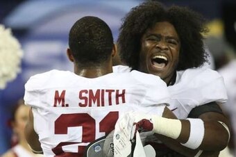 Brown celebrates the 2014 SEC Championship win with teammate Maurice Smith.