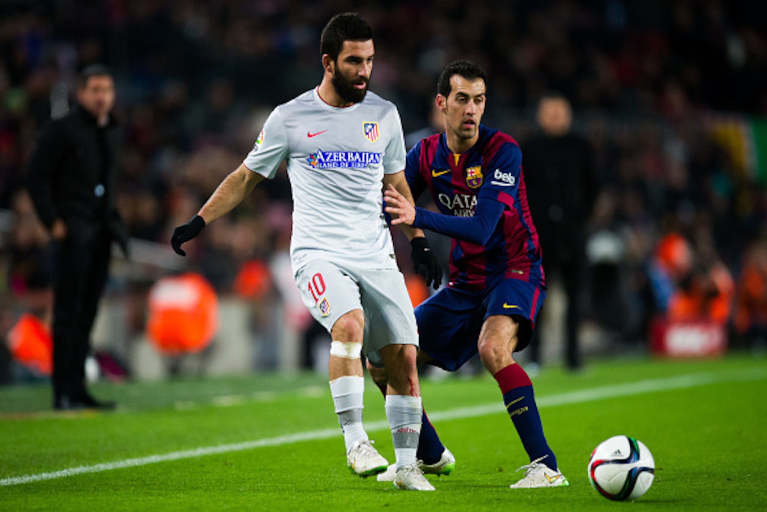BARCELONA, SPAIN - JANUARY 21: Arda Turan of Club Atletico de Madrid plays the ball next to Sergio Busquets of FC Barcelona during the Copa del Rey Quarter-Final First Leg match between FC Barcelona and Club Atletico de Madrid at Camp Nou on January 21, BARCELONA, SPAIN - JANUARY 21: Arda Turan of Club Atletico de Madrid plays the ball next to Sergio Busquets of FC Barcelona during the Copa del Rey Quarter-Final First Leg match between FC Barcelona and Club Atletico de Madrid at Camp Nou on January 21,