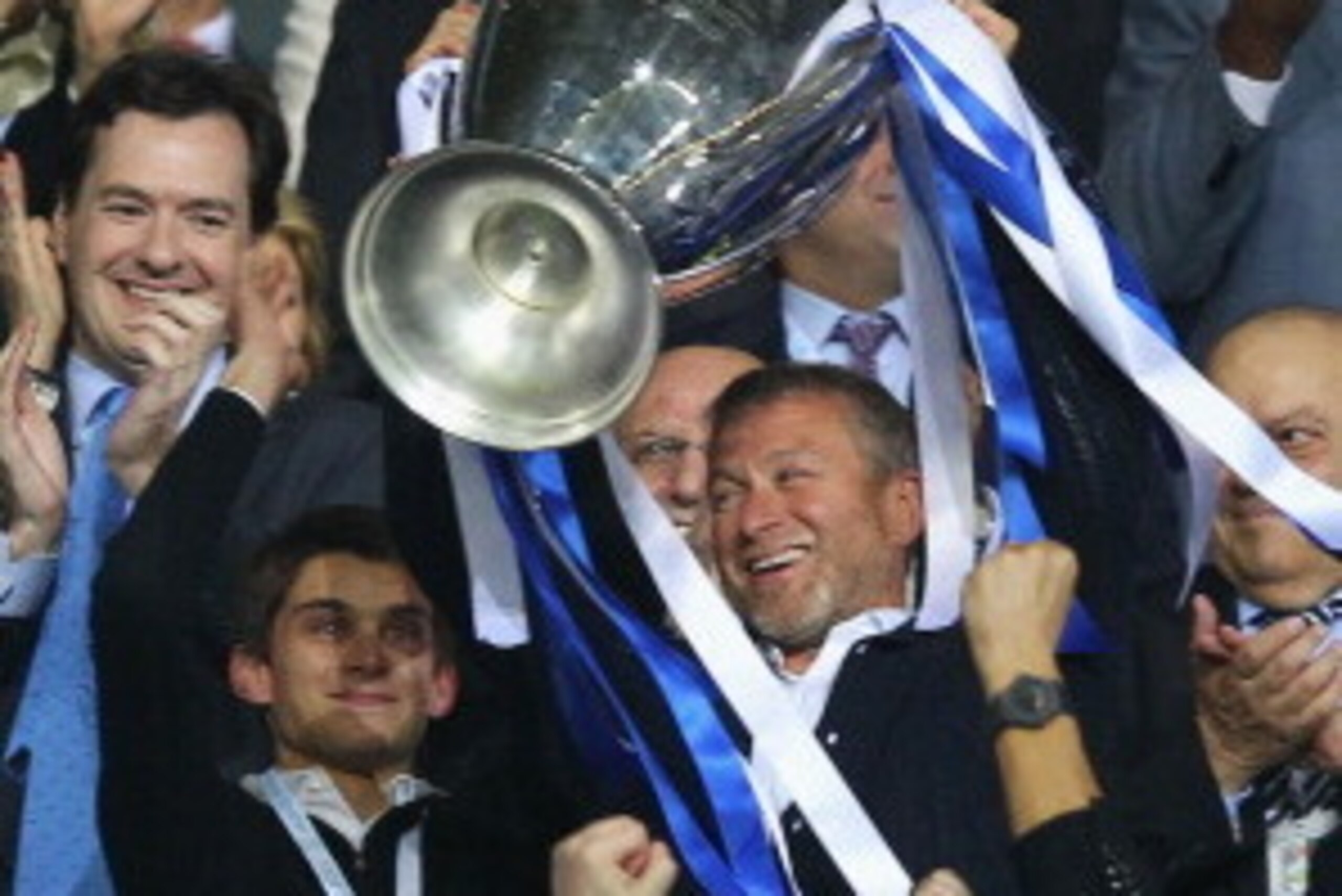 MUNICH, GERMANY - MAY 19:  Club owner Roman Abramovich (R) lifts the trophy in celebration while  Chancellor of the Exchequer George Osborne (C) applauds after their victory in the UEFA Champions League Final between FC Bayern Muenchen and Chelsea at the 
