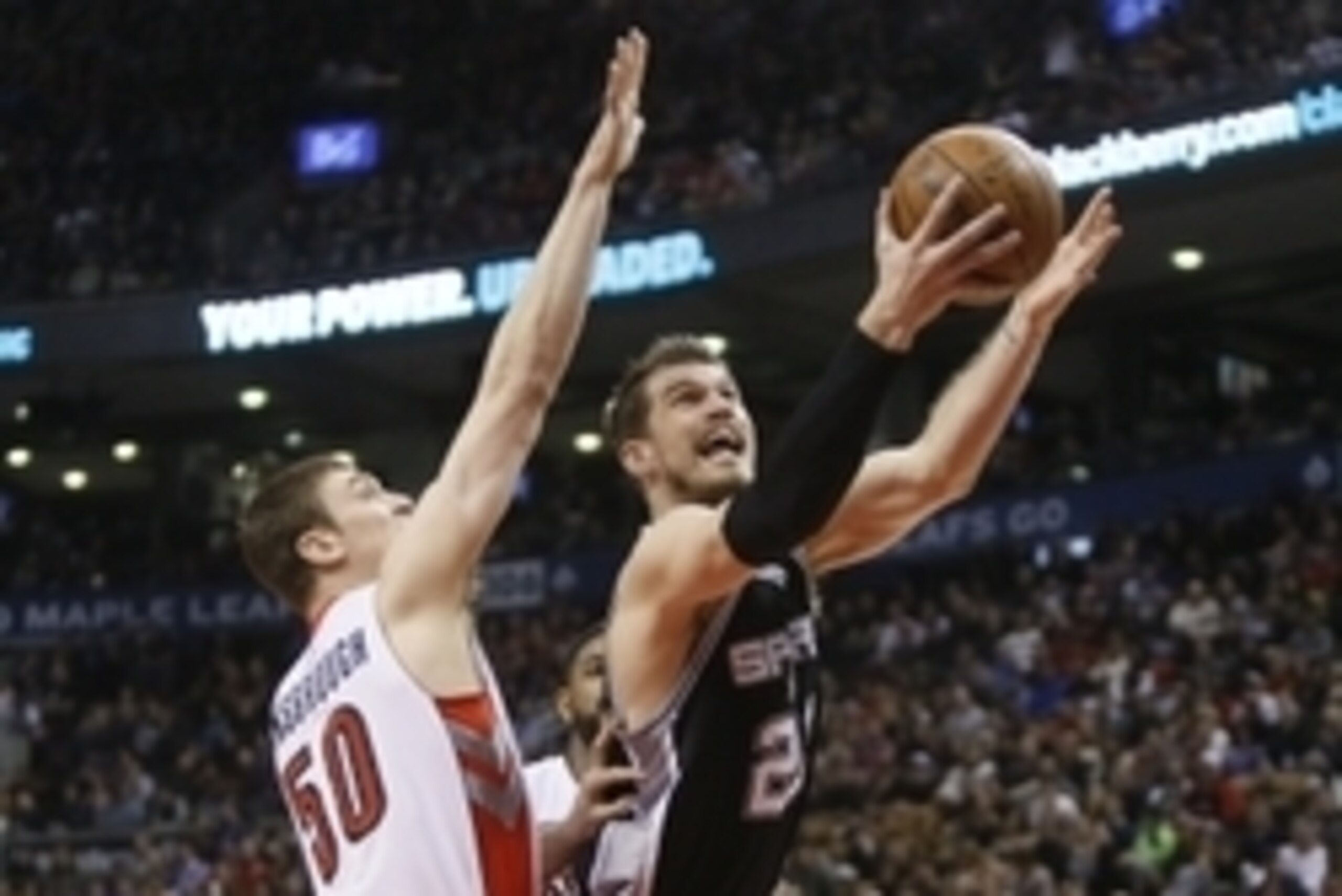 Feb 8, 2015; Toronto, Ontario, CAN; San Antonio Spurs center Tiago Splitter (22) goes up to make a basket as Toronto Raptors forward Tyler Hansbrough (50) defends during the first half at the Air Canada Centre. Mandatory Credit: John E. Sokolowski-USA TOD