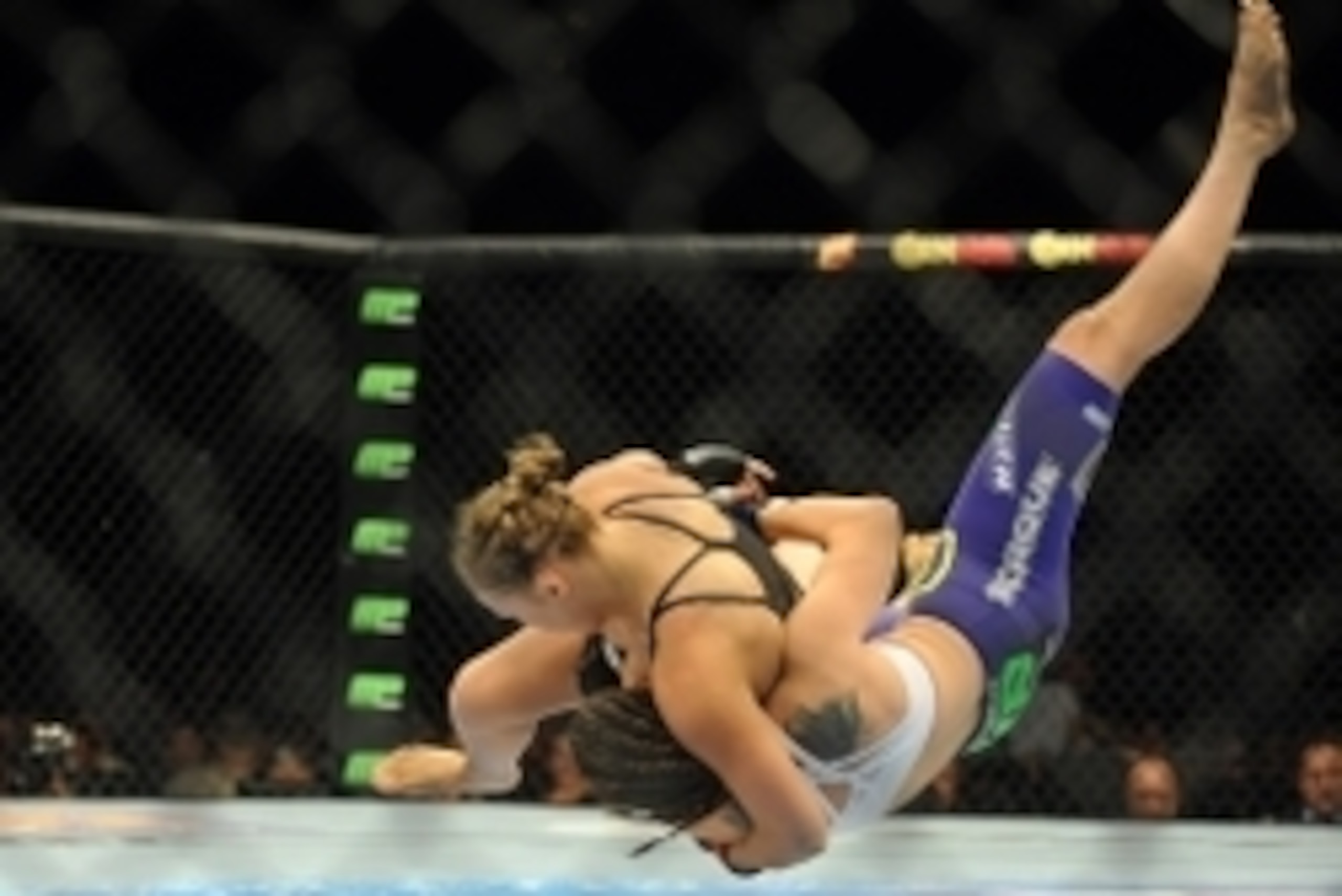 Jul 5, 2014; Las Vegas, NV, USA; Ronda Rousey (red gloves) takes down Alexis Davis (blue gloves) during the first round of a bantamweight fight at Mandalay Bay Events Center. Mandatory Credit: Stephen R. Sylvanie-USA TODAY Sports