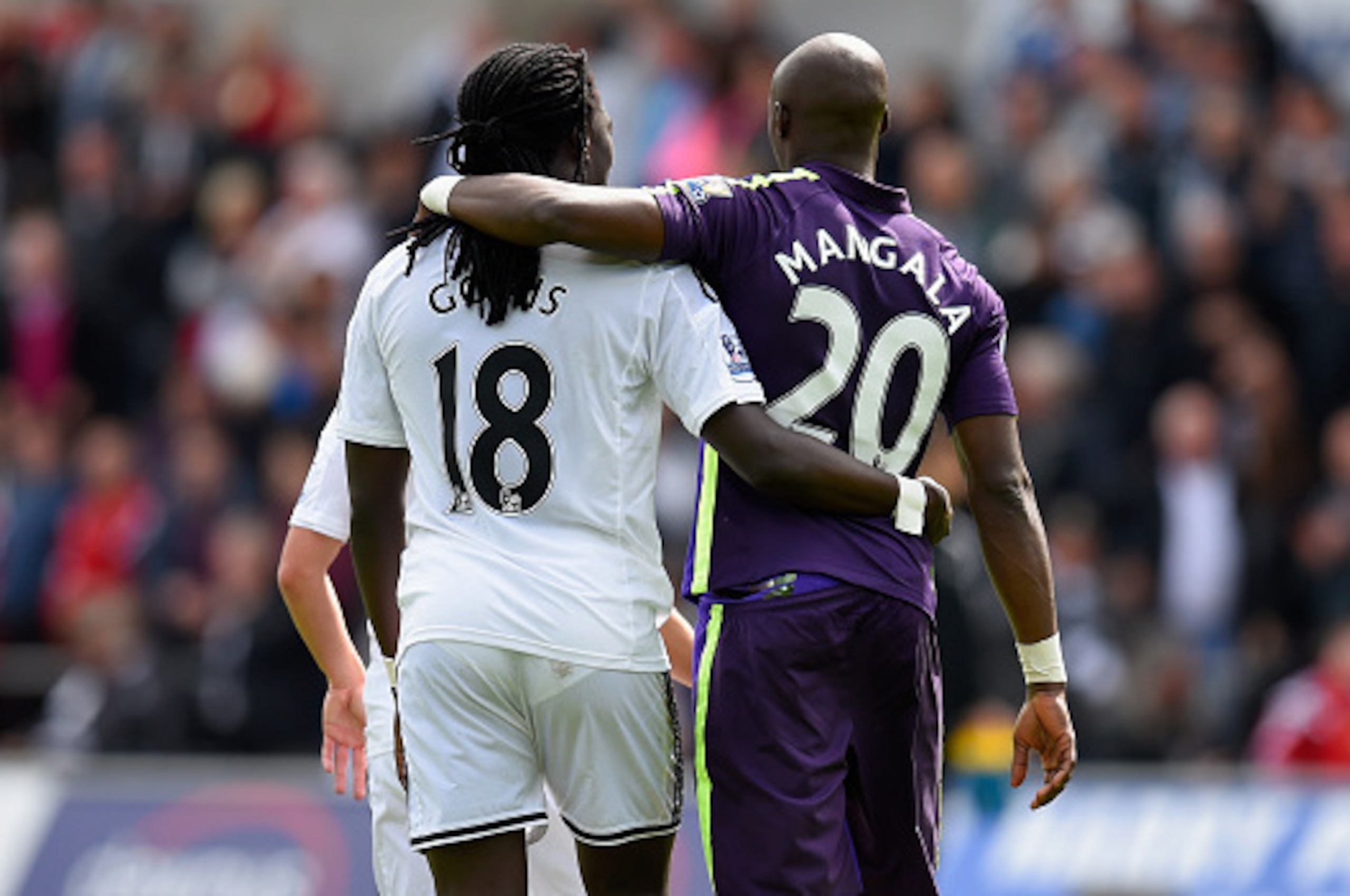 SWANSEA, WALES - MAY 17:  Swansea player Bafetimbi Gomis (l) and Eliaquim Mangala of City embrace after the Barclays Premier League match between Swansea City and Manchester City at Liberty Stadium on May 17, 2015 in Swansea, Wales.  (Photo by Stu Forster