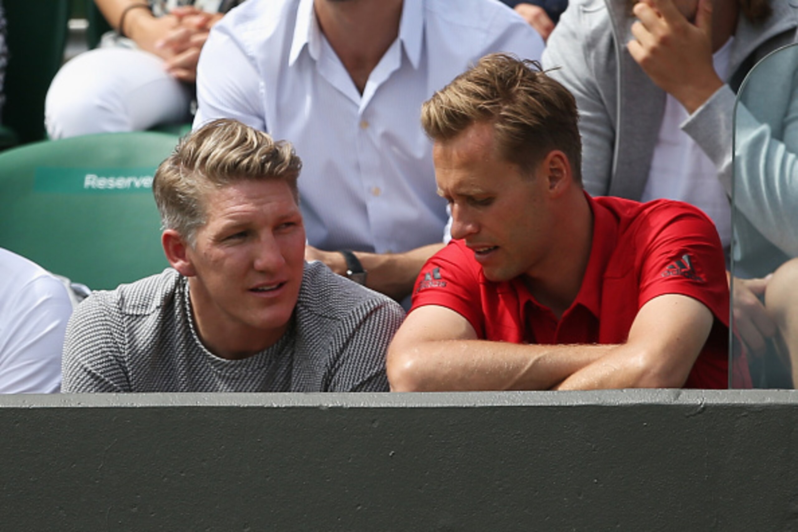 LONDON, ENGLAND - JUNE 29: German footballer Bastian Schweinsteiger (L) looks on as Ana Ivanovic of Serbia plays in her LadiesÂs Singles first round match against Yi-Fan Xu of China during day one of the Wimbledon Lawn Tennis Championships at the All Engl