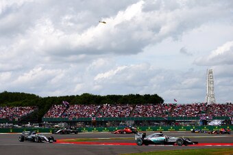NORTHAMPTON, ENGLAND - JULY 05:  Lewis Hamilton of Great Britain and Mercedes GP drives ahead of Nico Rosberg of Germany and Mercedes GP after resumption of the Formula One Grand Prix of Great Britain at Silverstone Circuit on July 5, 2015 in Northampton,