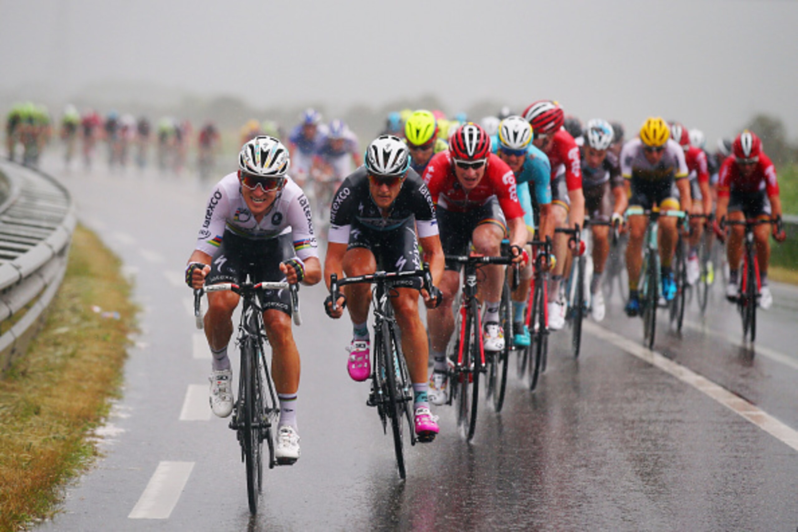 ZELANDE, NETHERLANDS - JULY 05:  Michal Kwiatkowski of Poland and Etixx-Quick Step (L) rides through the rain with the peloton during stage two of the 2015 Tour de France, a 166km stage between Utrecht and Zelande, on July 5, 2015 in Zelande, Netherlands.