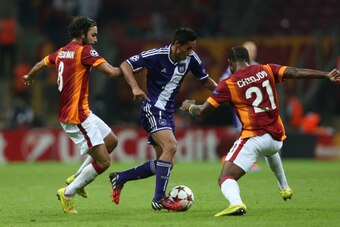 ISTANBUL, TURKEY -  SEPTEMBER 16: Galatasaray's Selcuk Inan (L) and Chedjou (R) in action with Anderlecht's Andy Najar (C) during their UEFA Champions Leauge group D match on September 16, 2014, at TT Arena Stadium in Istanbul, Turkey. (Photo by Burak Kar