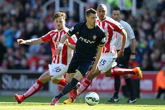 STOKE ON TRENT, ENGLAND - APRIL 18:  Morgan Schneiderlin of Southampton competes with Marko Arnautovic and Steven Nzonzi of Stoke during the Barclays Premier League match between Stoke City and Southampton at the Britannia Stadium on April 18, 2015 in Sto