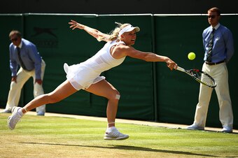 LONDON, ENGLAND - JULY 06:  Caroline Wozniacki of Denmark plays a backhand in her Ladies' Singles Fourth Round match against Garbine Muguruza of Spain during day seven of the Wimbledon Lawn Tennis Championships at the All England Lawn Tennis and Croquet C