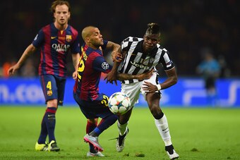 BERLIN, GERMANY - JUNE 06: Paul Pogba of Juventus battles for the ball with Daniel Alves of Barcelona during the UEFA Champions League Final between Juventus and FC Barcelona at Olympiastadion on June 6, 2015 in Berlin, Germany.  (Photo by Shaun Botterill