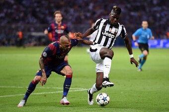BERLIN, GERMANY - JUNE 06: Paul Pogba of Juventus is challenged by Daniel Alves of Barcelona during the UEFA Champions League Final between Juventus and FC Barcelona at Olympiastadion on June 6, 2015 in Berlin, Germany.  (Photo by Matthias Hangst/Getty Im