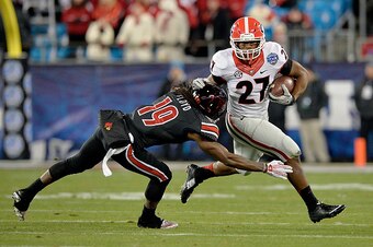 CHARLOTTE, NC - DECEMBER 30:  Nick Chubb #27 of the Georgia Bulldogs breaks away from Terell Floyd #19 of the Louisville Cardinals during the Belk Bowl at Bank of America Stadium on December 30, 2014 in Charlotte, North Carolina.  (Photo by Grant Halverso