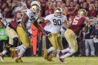 Oct 18, 2014; Tallahassee, FL, USA; Florida State Seminoles quarterback Jameis Winston (5) is pressured by Notre Dame Fighting Irish defensive lineman Isaac Rochell (90) and defensive lineman Jarron Jones (94) in the second quarter at Doak Campbell Stadiu