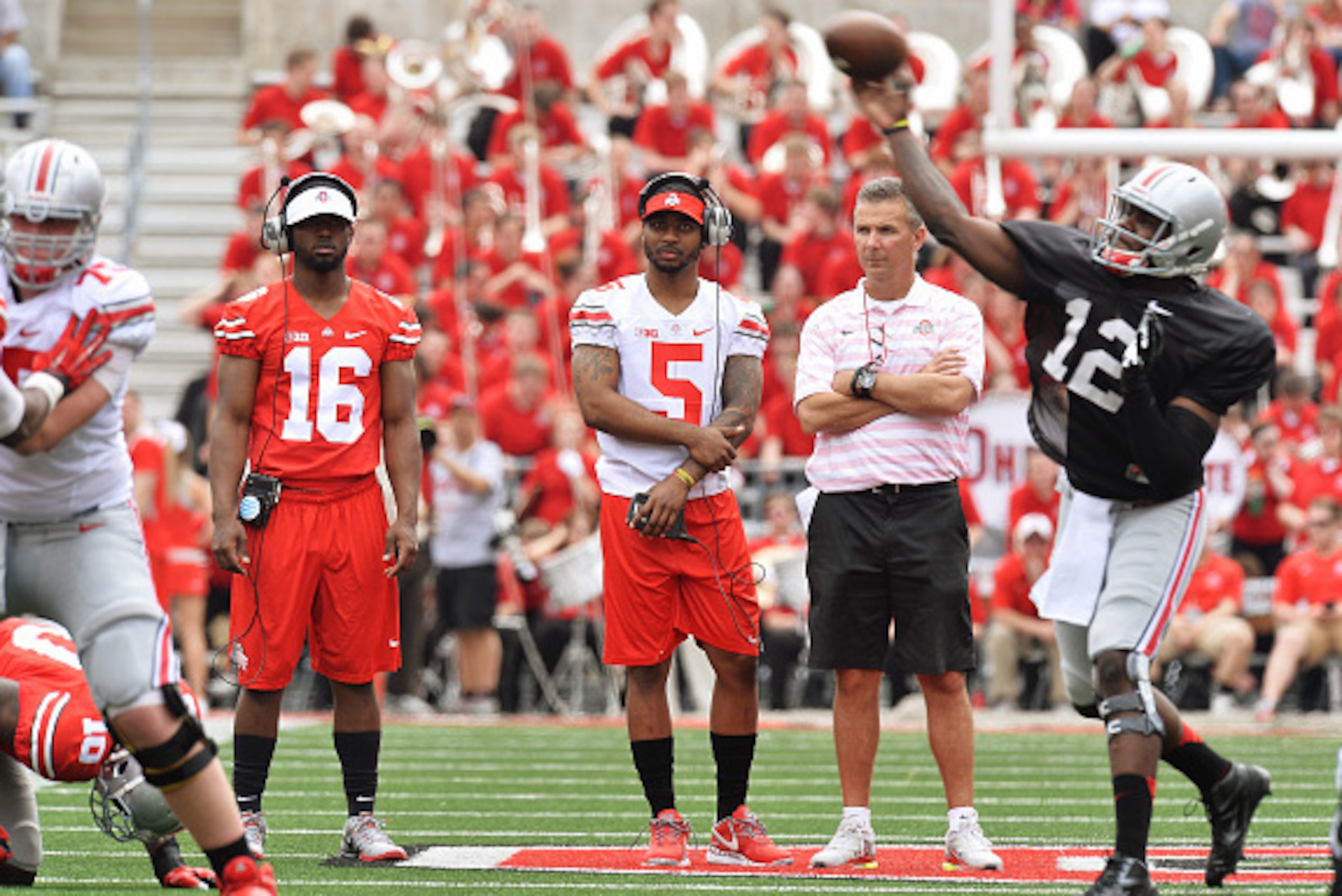 COLUMBUS, OH - APRIL 18: Quarterbacks J.T. Barrett #16 of the Ohio State Buckeyes and Braxton Miller #5 of the Ohio State Buckeyes watch alongside Head Coach Urban Meyer of the Ohio State Buckeyes as Cardale Jones #12 of the Ohio State Buckeyes runs the COLUMBUS, OH - APRIL 18: Quarterbacks J.T. Barrett #16 of the Ohio State Buckeyes and Braxton Miller #5 of the Ohio State Buckeyes watch alongside Head Coach Urban Meyer of the Ohio State Buckeyes as Cardale Jones #12 of the Ohio State Buckeyes runs the