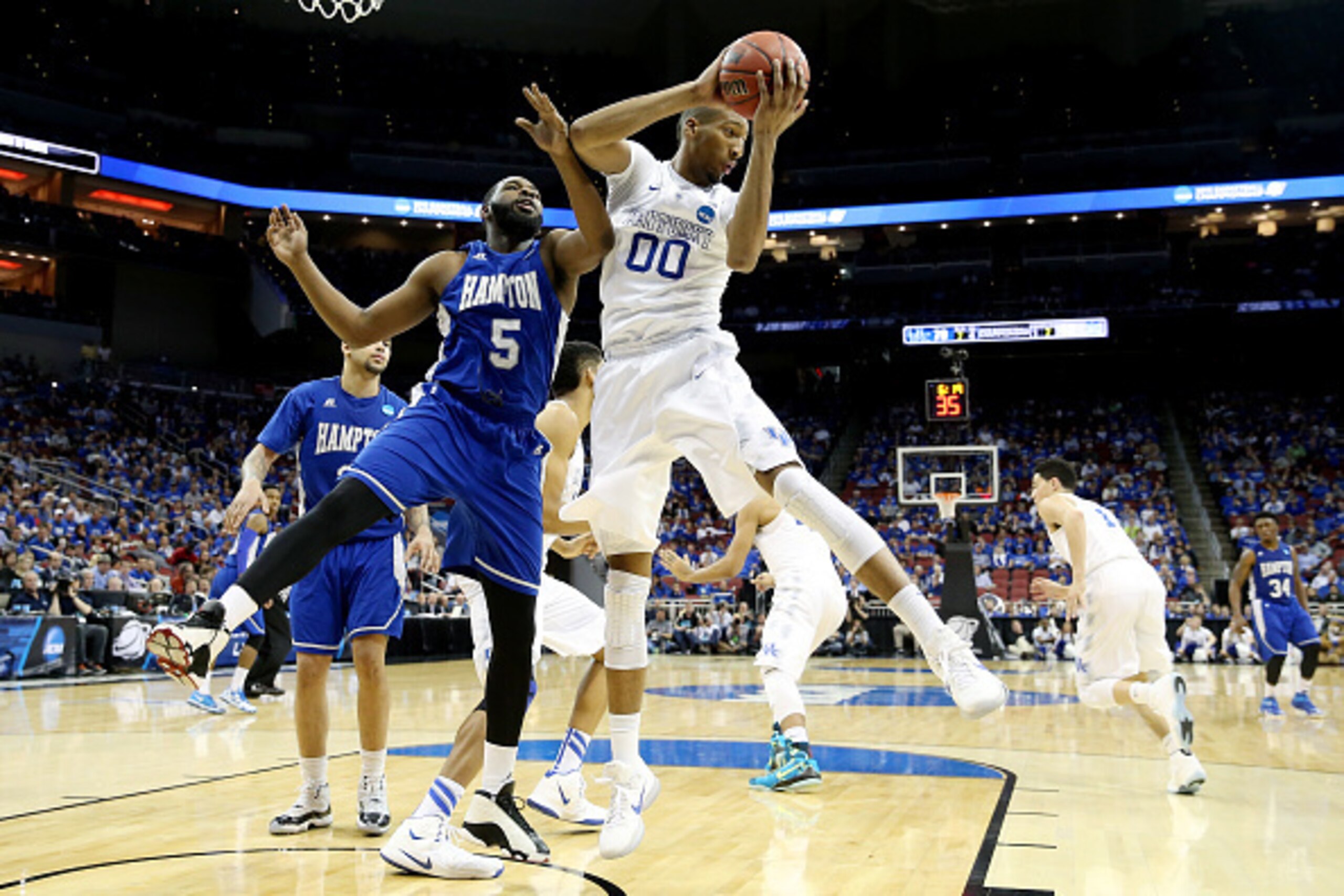 LOUISVILLE, KY - MARCH 19: Marcus Lee #00 of the Kentucky Wildcats grabs a rebound against Emmanuel Okoroba #5 of the Hampton Pirates during the second round of the 2015 NCAA Men's Basketball Tournament at the KFC YUM! Center on March 19, 2015 in Louisvil