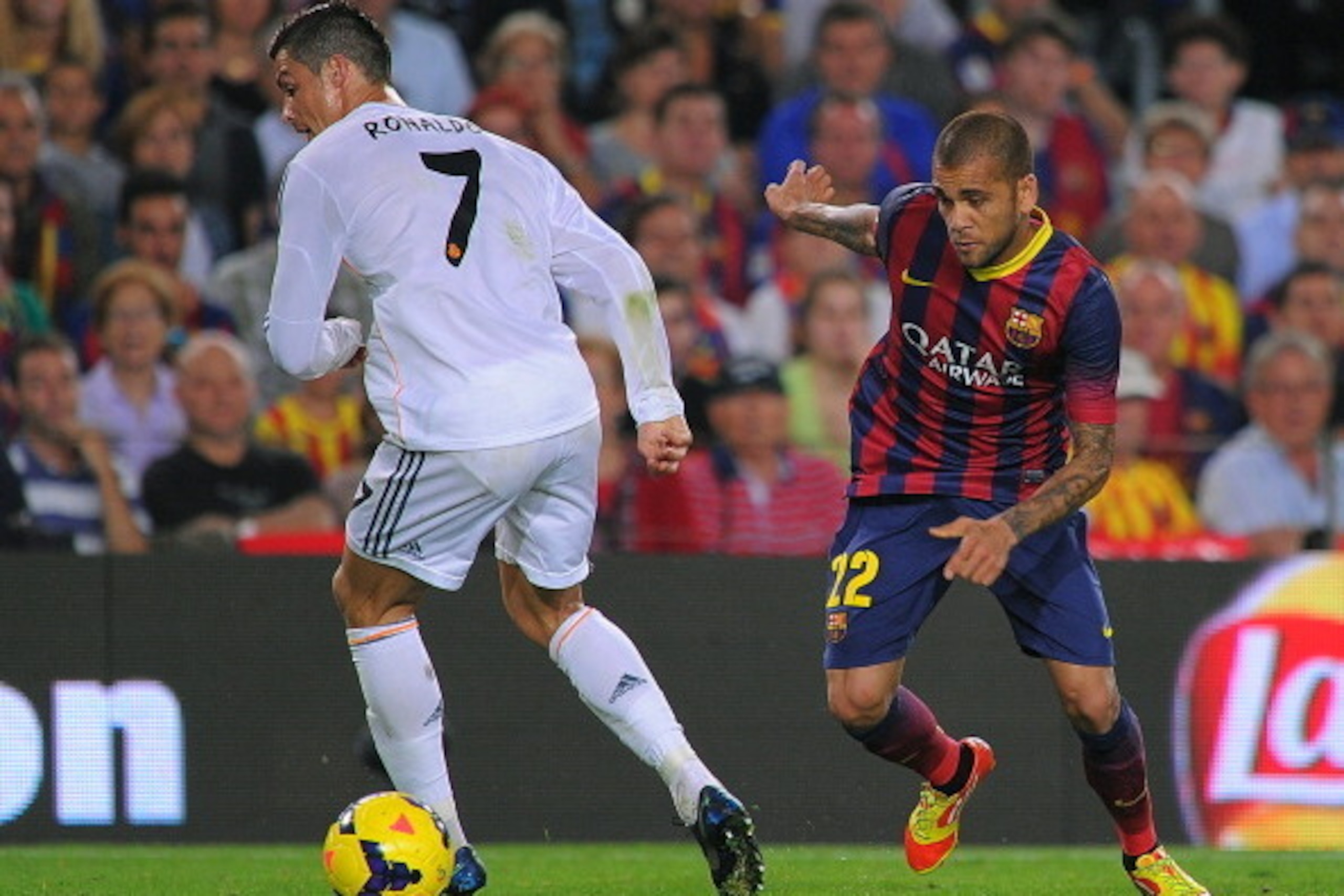 BARCELONA, SPAIN - OCTOBER 26:  Dani Alves of FC Barcelona (R) passes the ball  through the legs Cristiano Ronaldo of Real Madrid during the La Liga match between FC Barcelona and Real Madrid CF at Camp Nou stadium on October 26, 2013 in Barcelona, Spain.