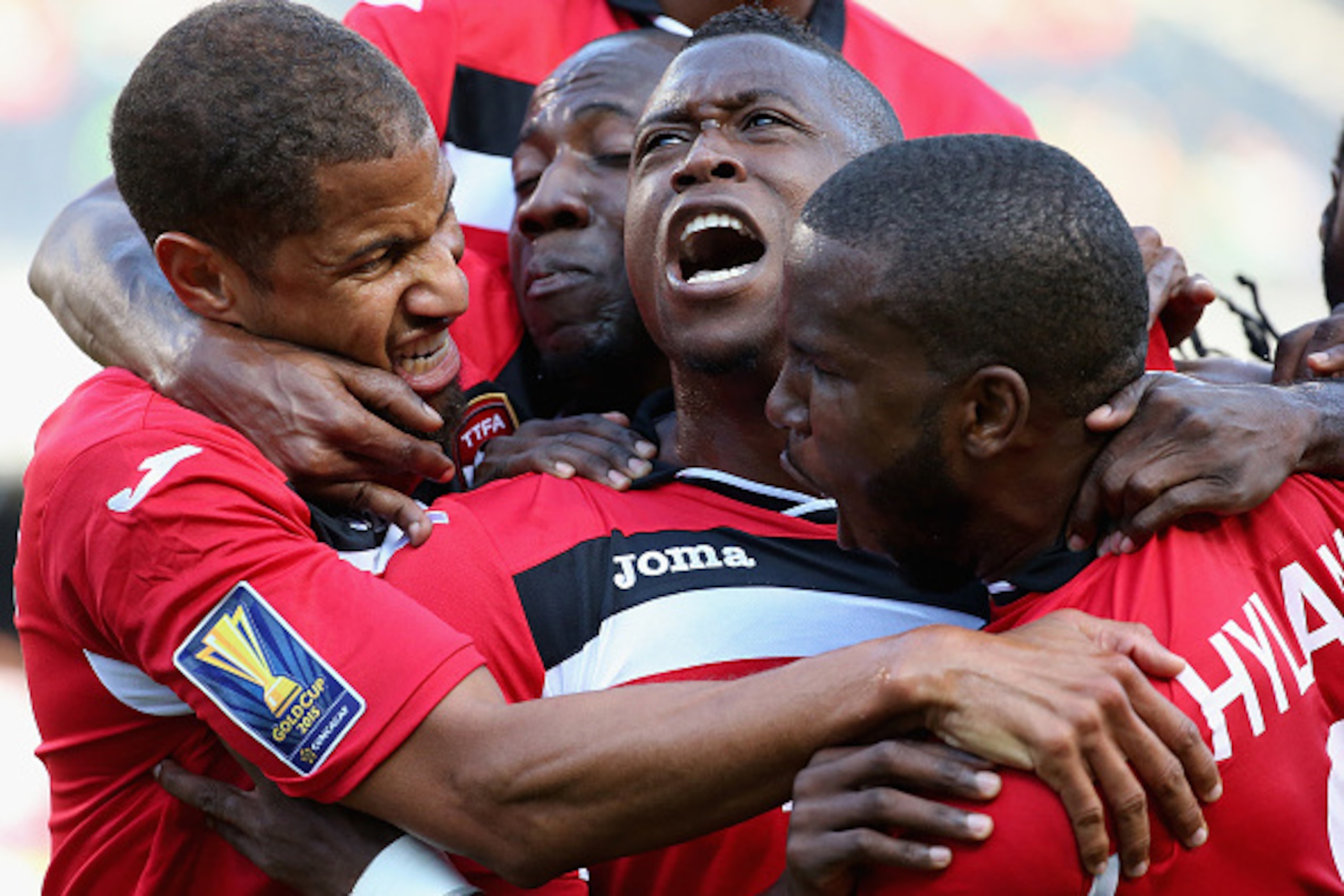 CHICAGO, IL - JULY 09:  Sheldon Bateau #4 of Trinidad & Tobago (Center) celebrates a first half goal against Guatemala with teammates including Radanfah Abu Bakr #6 (L) and Khaleem Hyland #8 (R) during a match in the 2015 CONCACAF Gold Cup at Soldier Fiel