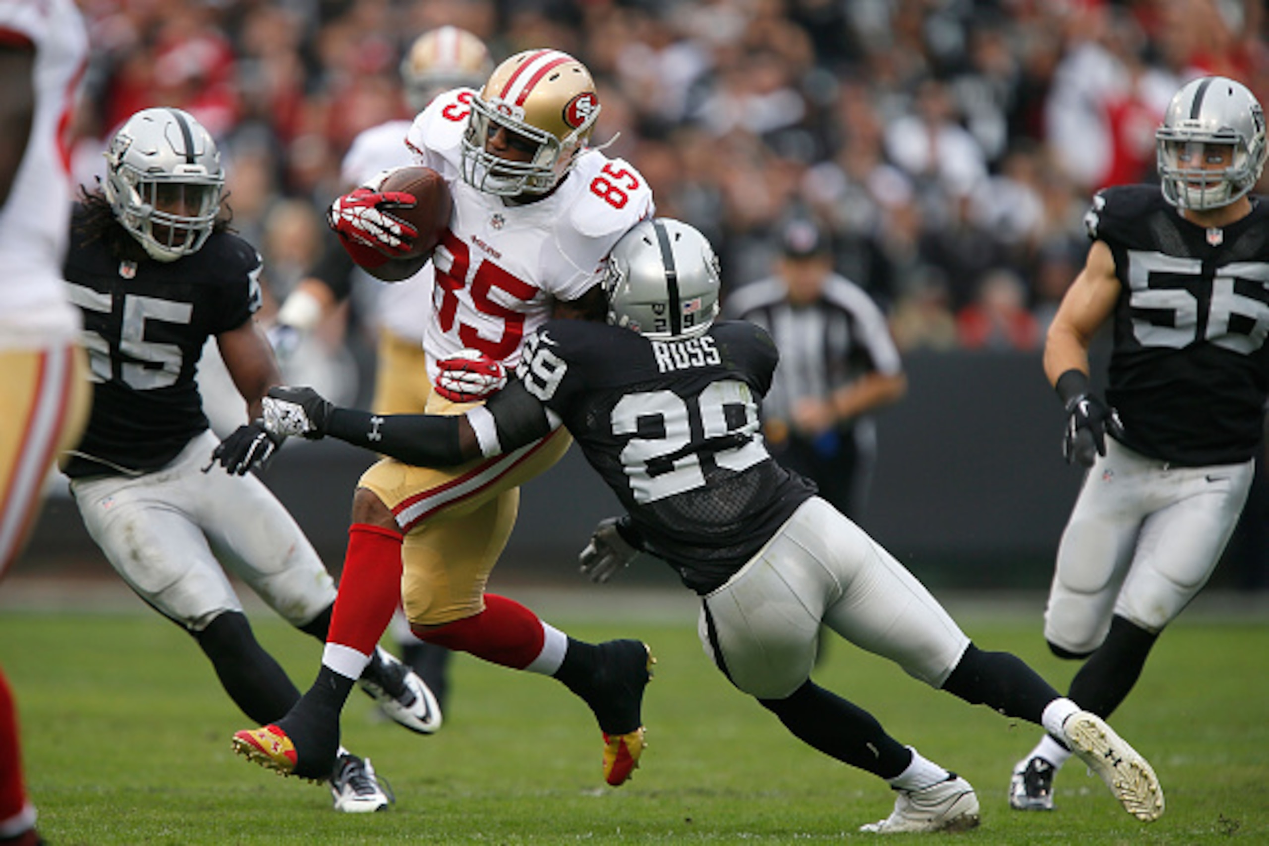 OAKLAND, CA - DECEMBER 07:  Vernon Davis #85 of the San Francisco 49ers gets past Brandian Ross #29 of the Oakland Raiders in the first quarter at O.co Coliseum on December 7, 2014 in Oakland, California.  (Photo by Brian Bahr/Getty Images)