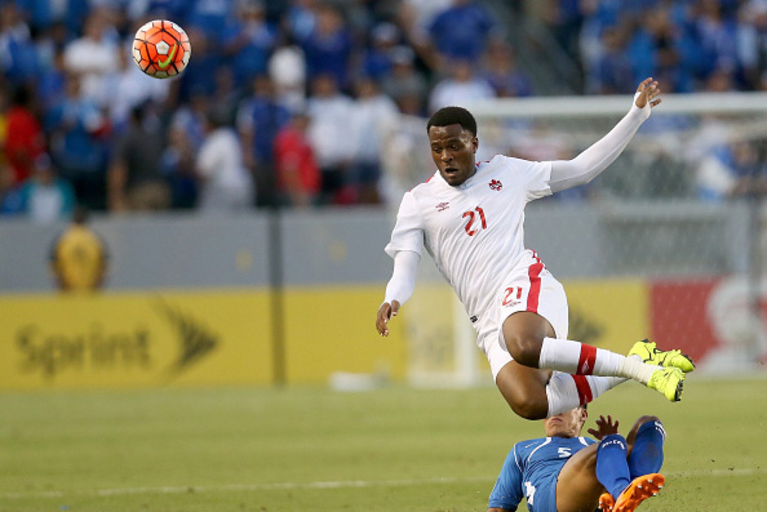 LOS ANGELES, CA - JULY 08:  Cyle Larin #21 of Canada goes down as he is fouled by Alexander Mendoza #5 of El Salvador in their CONCACAF Gold Cup Group B match at StubHub Center on July 8, 2015 in Los Angeles, California.  The match ended in a 0-0 draw.  (