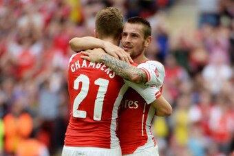 LONDON, ENGLAND - AUGUST 10: Calum Chambers of Arsenal is hugged by team-mate Mathieu Debuchy of Arsenal during the FA Community Shield match between Manchester City and Arsenal at Wembley Stadium on August 10, 2014 in London, England.  (Photo by Ross Kin