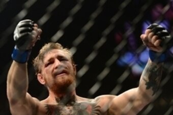 Jul 11, 2015; Las Vegas, NV, USA;  Conor McGregor (blue gloves) celebrates after defeating Chad Mendes (not pictured) in their interim featherweight title bout during UFC 189 at MGM Grand Garden Arena. McGregor won via second round TKO. Mandatory Credit: 