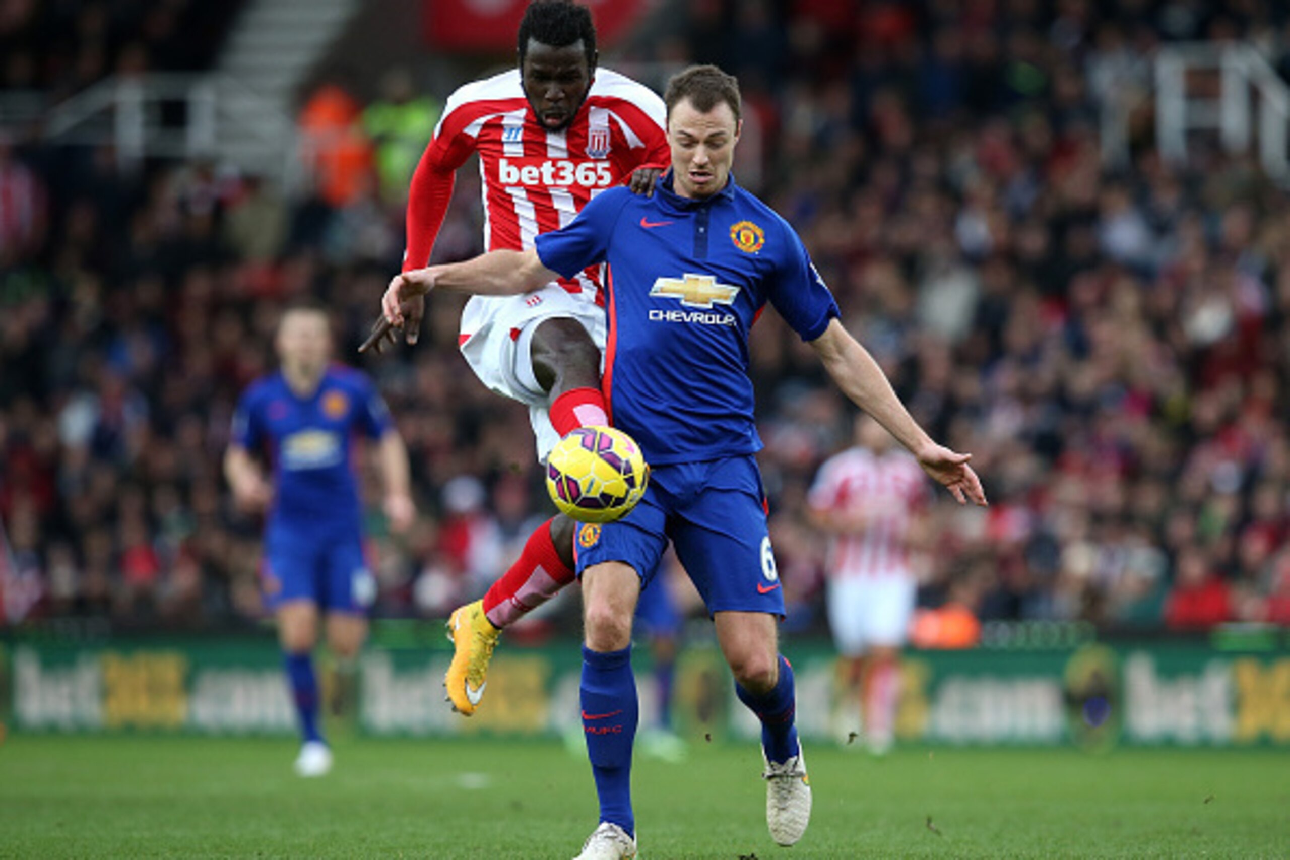 STOKE ON TRENT, ENGLAND - JANUARY 01:  Jonny Evans of Manchester United competes with Mame Diouf of Stoke City during the Barclays Premier League match between Stoke City and Manchester United at Britannia Stadium on January 1, 2015 in Stoke on Trent, Eng