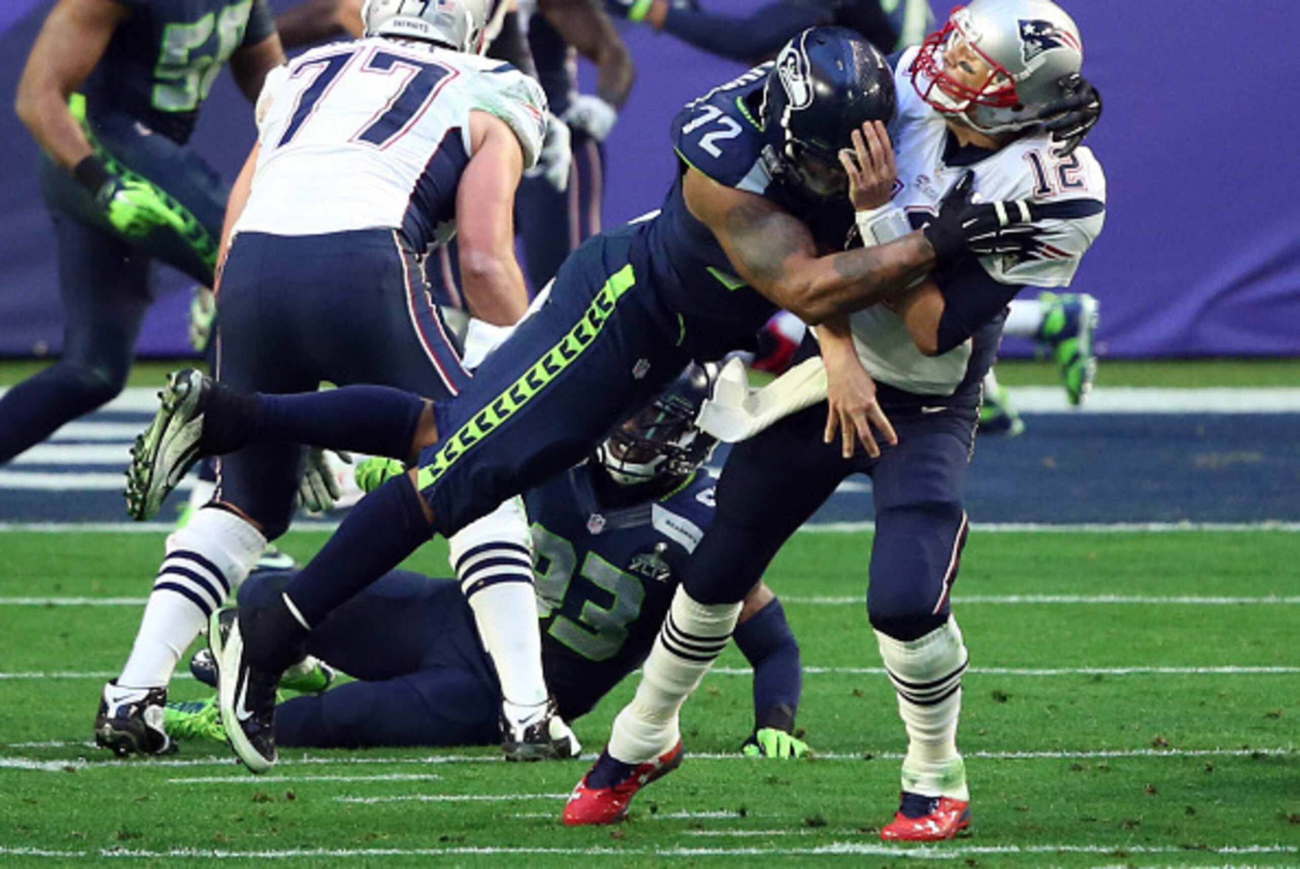 GLENDALE, AZ - FEBRUARY 01:  Michael Bennett #72 of the Seattle Seahawks hits  Tom Brady #12 of the New England Patriots in the first half during Super Bowl XLIX at University of Phoenix Stadium on February 1, 2015 in Glendale, Arizona.  (Photo by Andy Ly