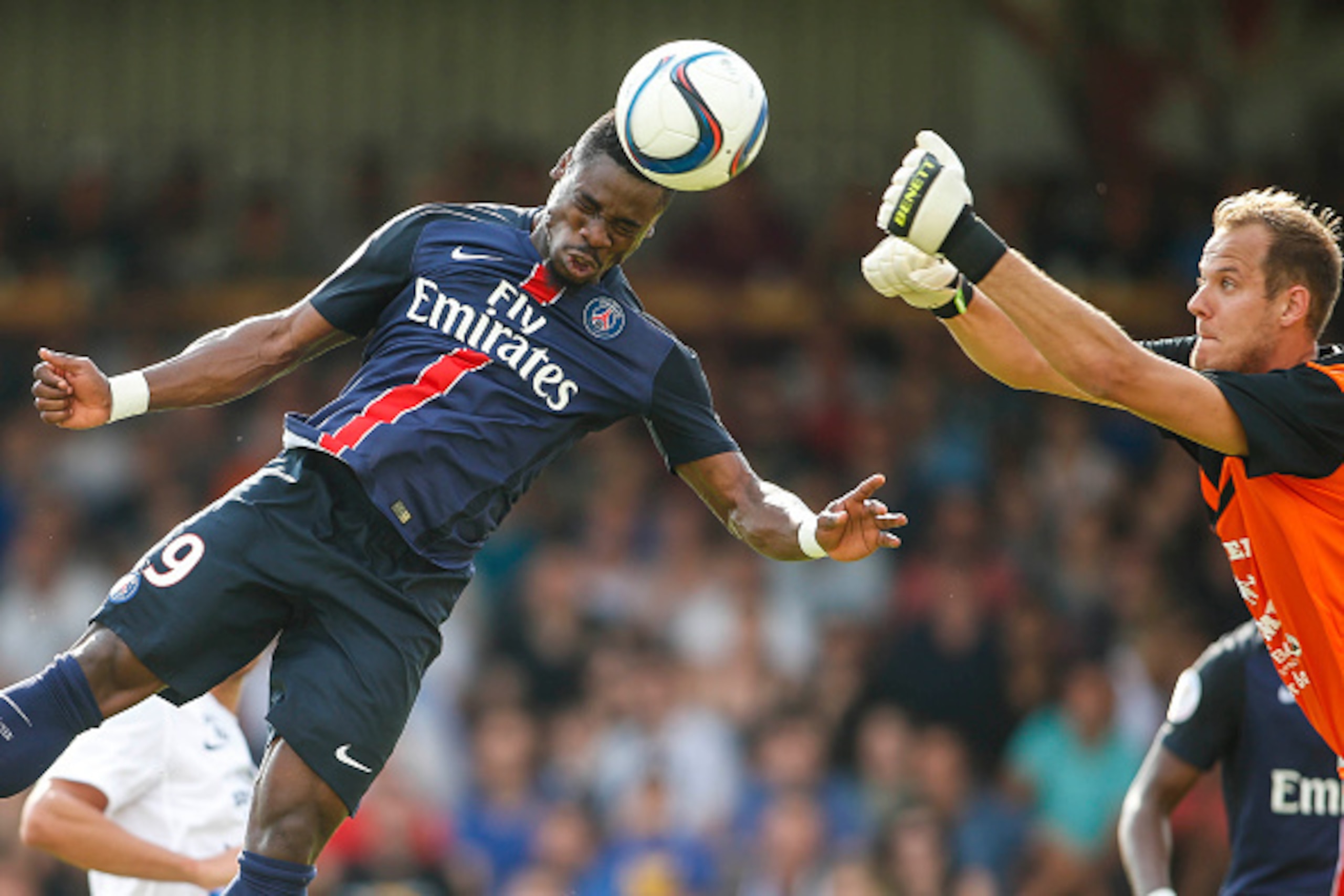 VIENNA, AUSTRIA - JULY 12:  Serge Aurier of Paris Saint-Germain (L) competes for the ball in the air with Goalkeeper David Kraft of Wiener Sportklub during the Friendly Match between Wiener Sportklub and Paris Saint-Germain at Sportclub Platz on July 12, 