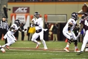 Nov 28, 2014; Blacksburg, VA, USA; Virginia Cavaliers quarterback Greyson Lambert (11) looks to pass as running back Kevin Parks (25) and guard Conner Davis (74) block in the first quarter at Lane Stadium. Mandatory Credit: Bob Donnan-USA TODAY Sports