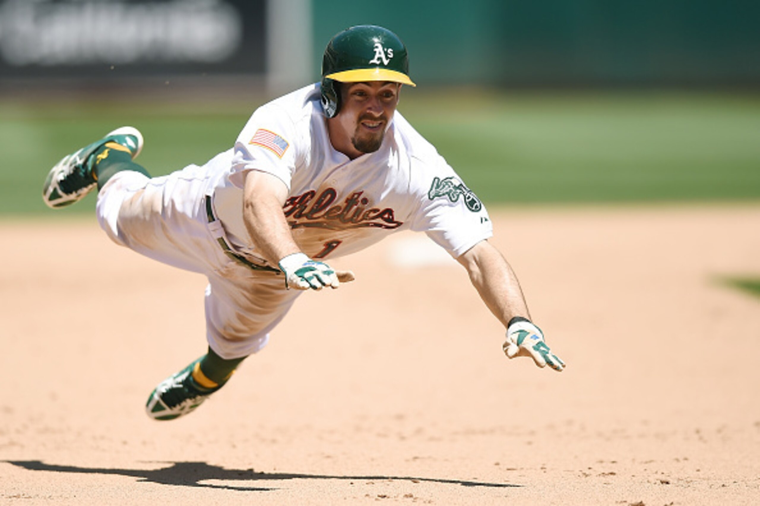 OAKLAND, CA - JULY 04:  Billy Burns #1 of the Oakland Athletics dives into third base safe against the Seattle Mariners in the bottom of the seventh inning at O.co Coliseum on July 4, 2015 in Oakland, California. Burns went from first to third on a single