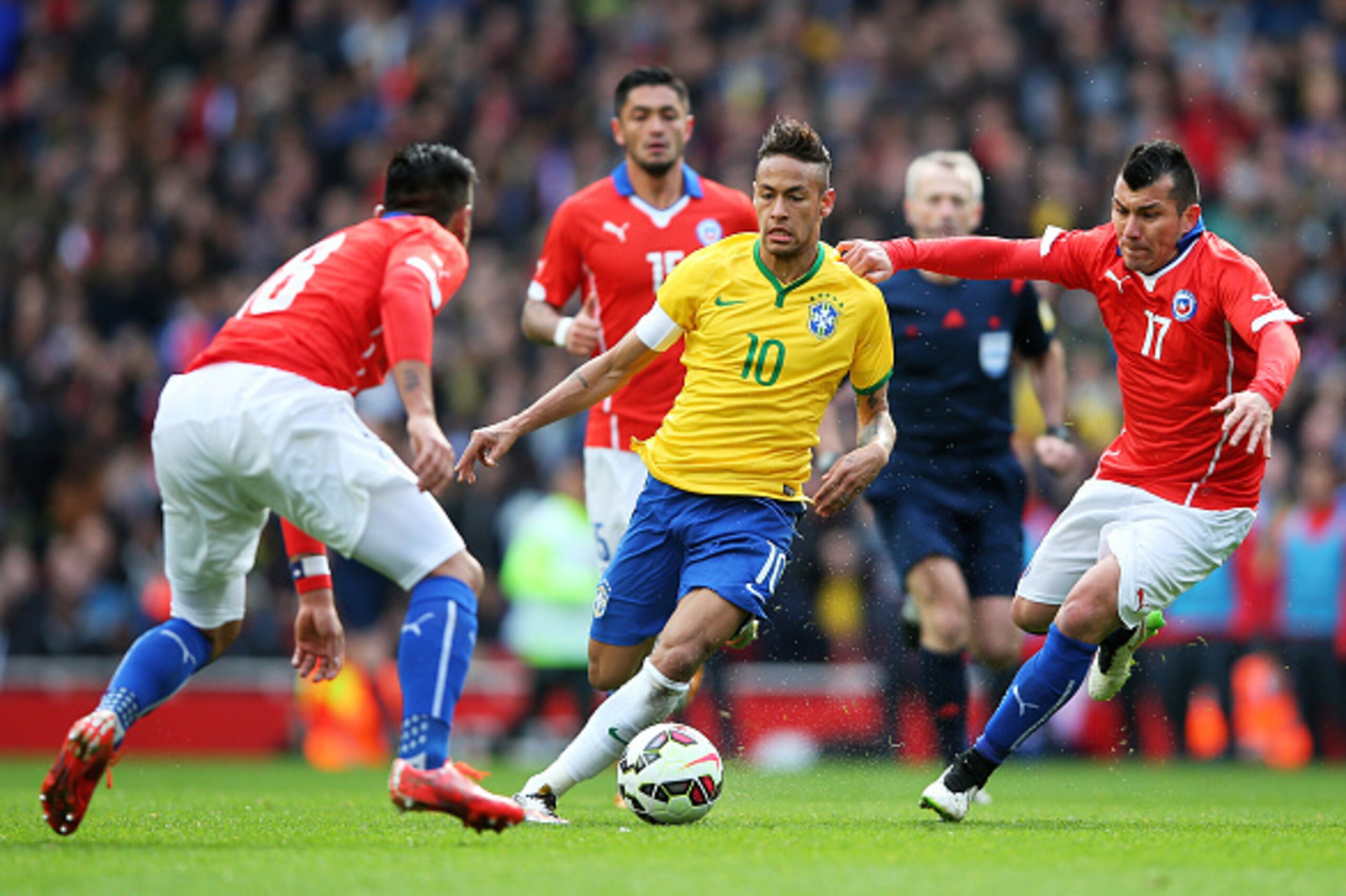 LONDON, ENGLAND - MARCH 29:  Neymar of Brazil controls the ball as Gonzalo Jara (L) and Gary Medel (R) of Chile close in during the international friendly match between Brazil and Chile at the Emirates Stadium on March 29, 2015 in London, England.  (Photo