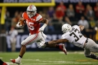 Jan 12, 2015; Arlington, TX, USA; Ohio State Buckeyes running back Ezekiel Elliott (15) runs past Oregon Ducks linebacker Tyson Coleman (33) in the 2015 CFP National Championship Game at AT&T Stadium. Ohio State won 42-20. Mandatory Credit: Tim Heitman-US